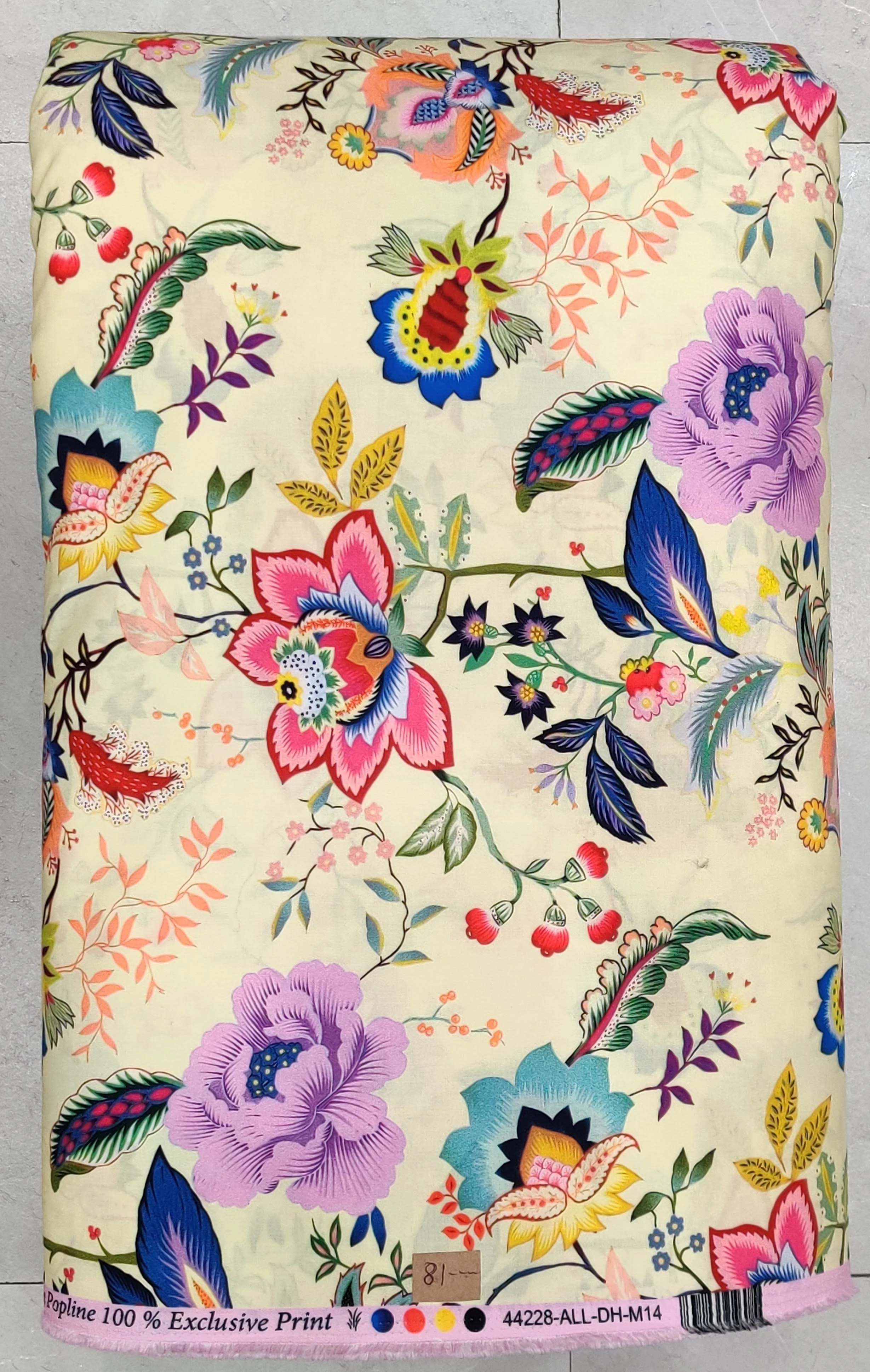 Crisp ivory or off-white background featuring a vibrant, multicolored tropical floral print with large blooming hibiscus flowers, lush green tropical leaves, and small exotic bird accents.