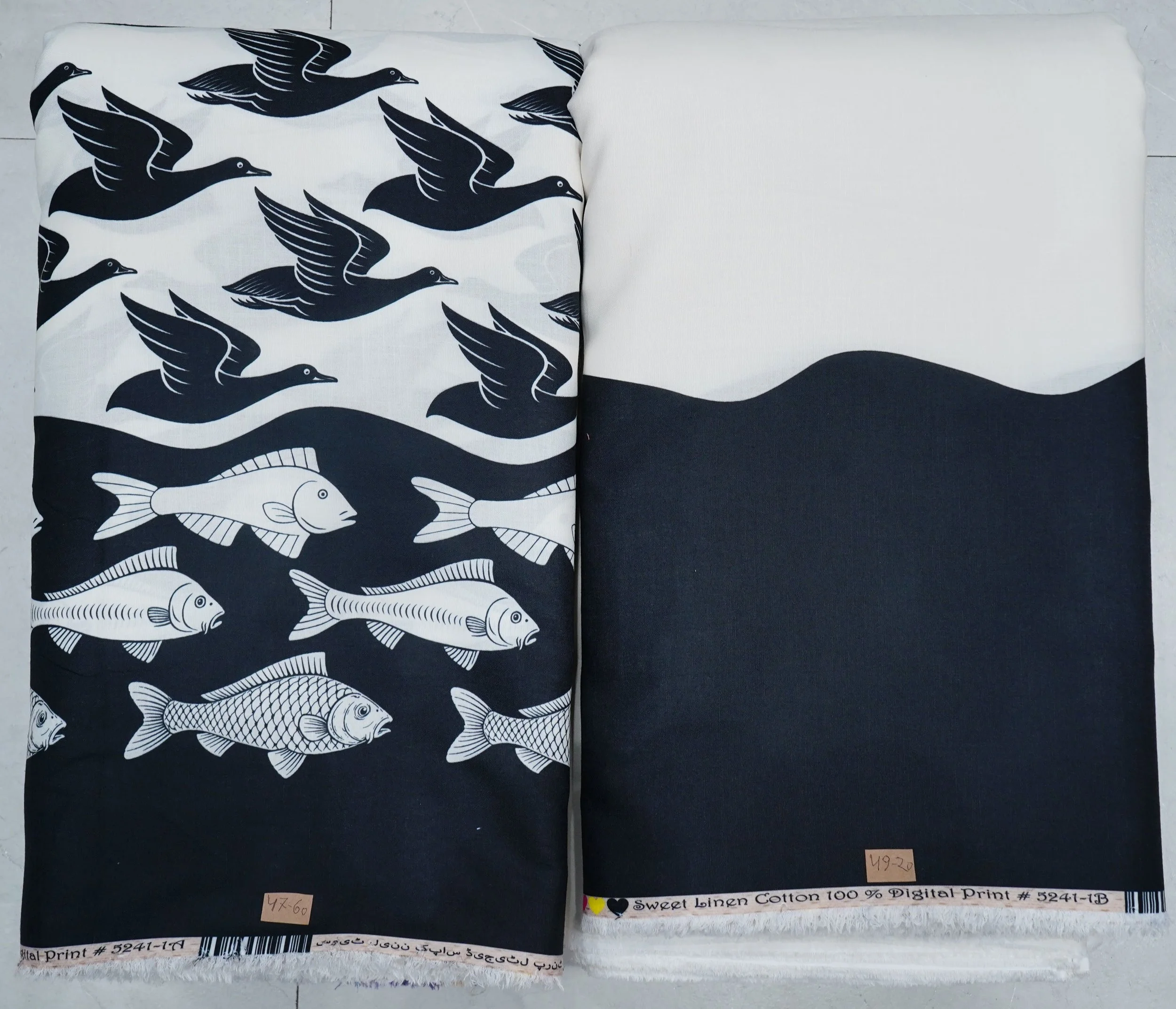 Crisp navy-blue and snow-white border-print fabric featuring an artful maritime design with stylized flying sea birds along the top, detailed swimming fish along the bottom, and a scalloped dividing line.