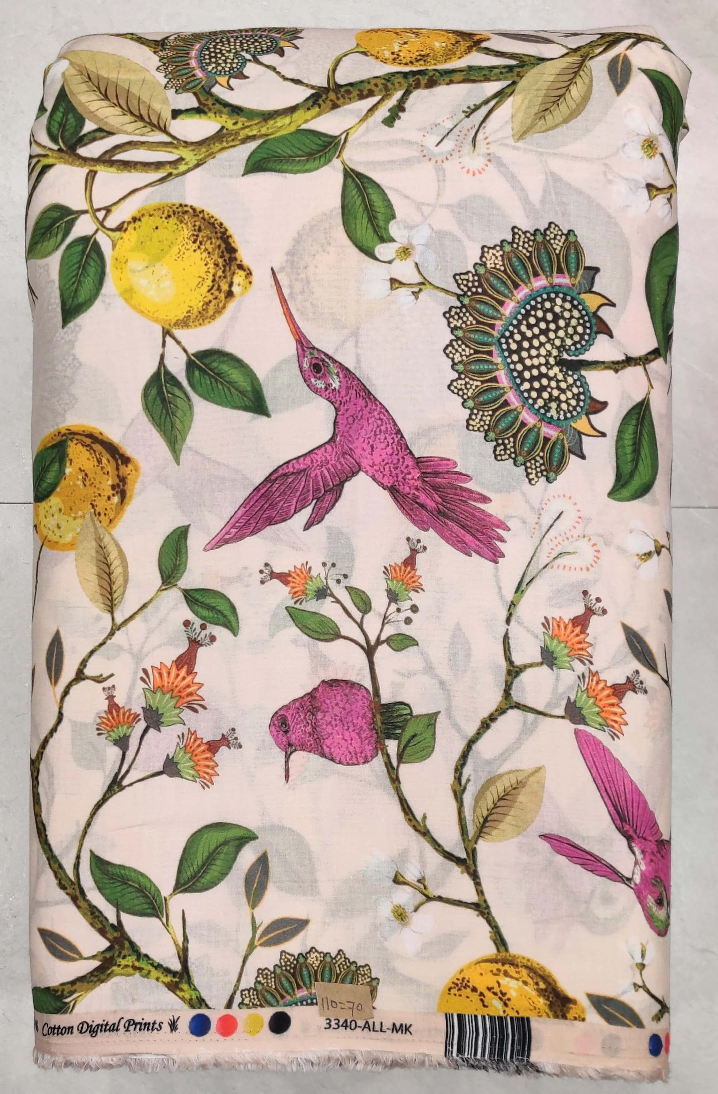 Crisp white fabric featuring a vibrant botanical print with magenta hummingbirds, yellow lemons, and green foliage.