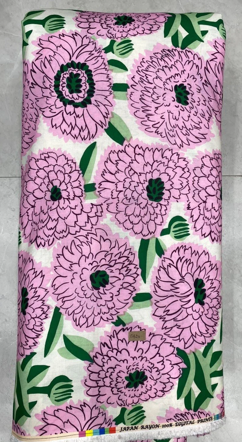 Soft white fabric featuring a dense pattern of large pink blossoms with detailed dark centers, rich green foliage, and delicate stems.