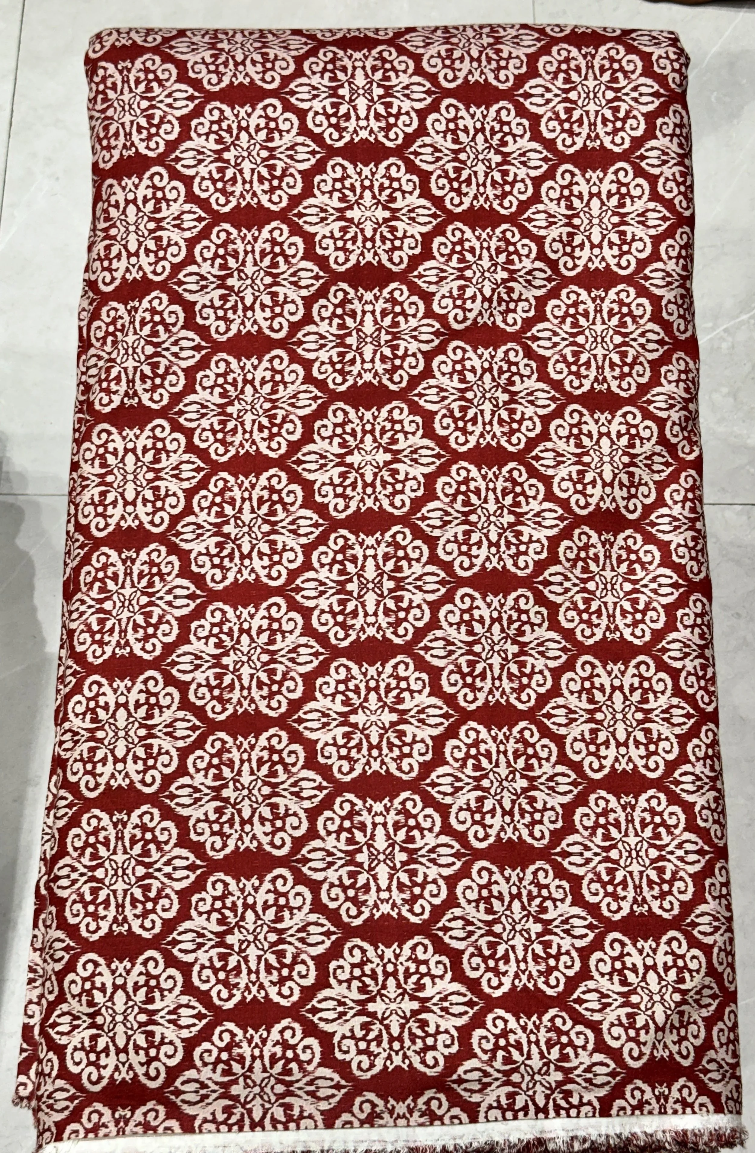 Rich red and white fabric featuring an intricate, ornate damask-style medallion pattern with detailed vintage motifs.