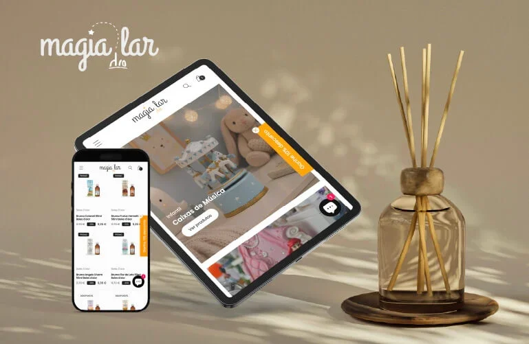 Imagem de uma loja online chamada 'Magia Lar' exibida em um tablet e um celular, com produtos de decoração e itens musicais, ao lado de um difusor de aromas de vidro com palitos de madeira, em um ambiente com luz suave.