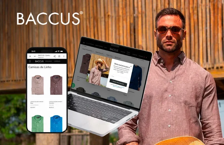 Homem com óculos escuros segurando chapéu, ao lado de um laptop e um smartphone exibindo uma loja online de camisetas de linho, com fundo de jardim e cerca de madeira.