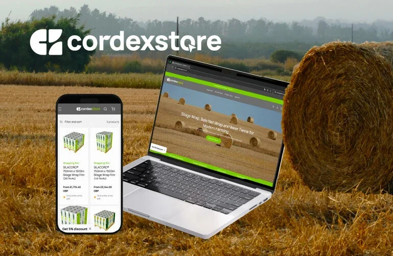 Imagem de um campo de plantação com fardos de feno, um laptop aberto mostrando o site da Cordexstore e um smartphone também exibindo o site, com o logo da Cordexstore no topo