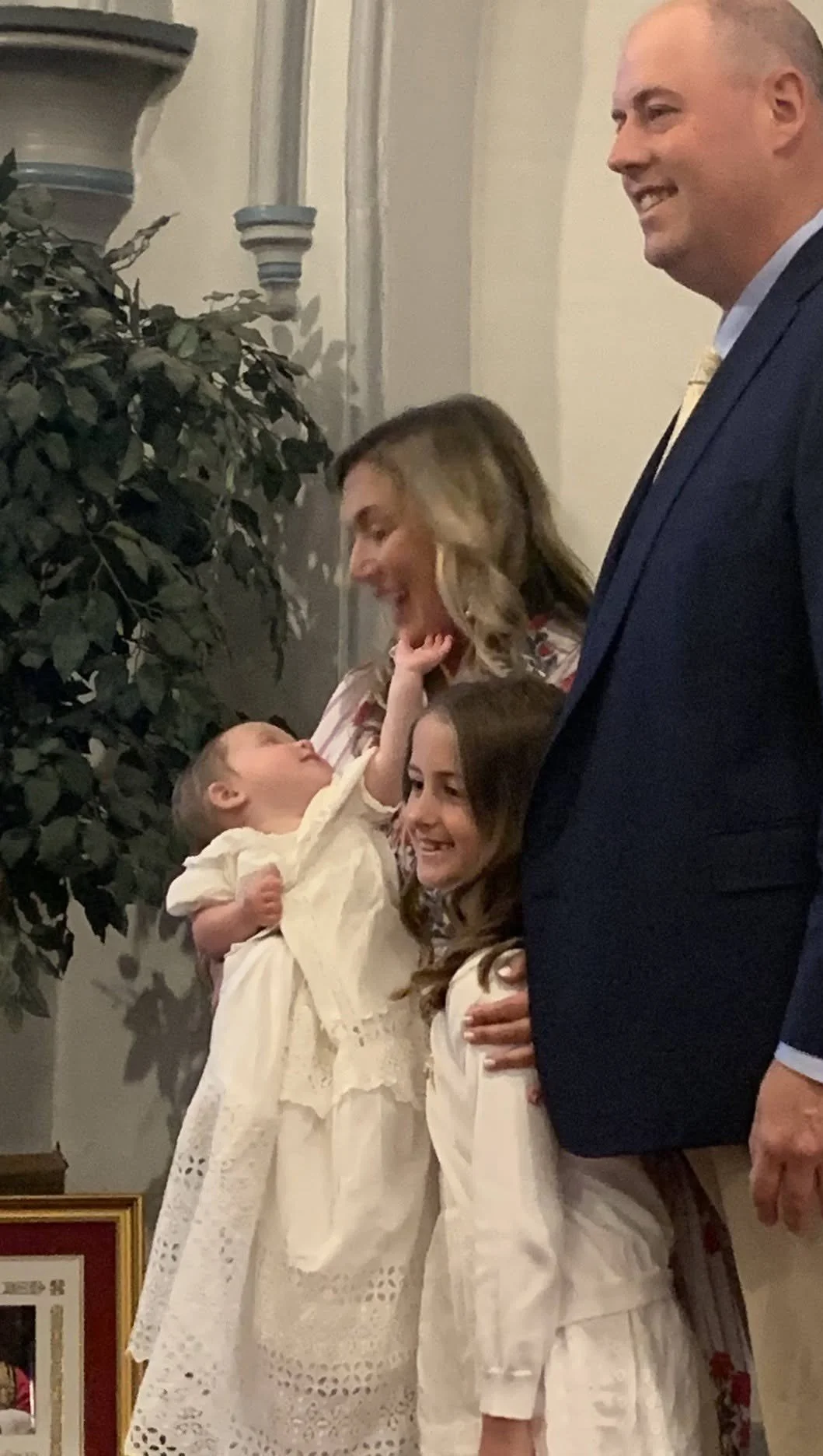 New Baptized baby reaches for Mother