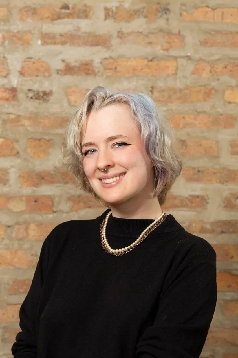 Person with striped sweater against brick wall