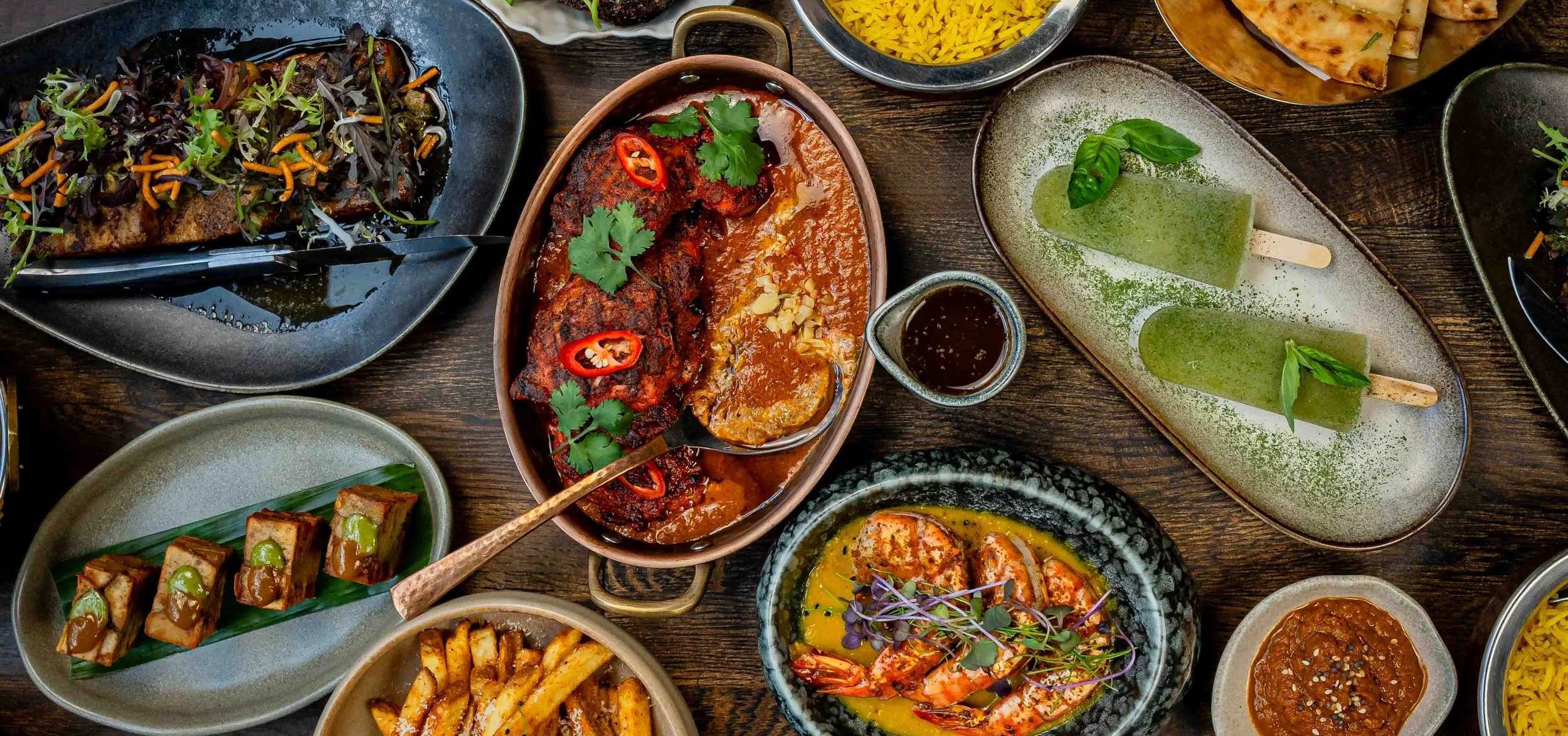 Halal Indian-Pakistani sharing dishes at Zahida in Copenhagen – curried tiger prawns, grilled meat with chilli and coriander, potato bites on banana leaf, masala fries and lime-basil kulfi