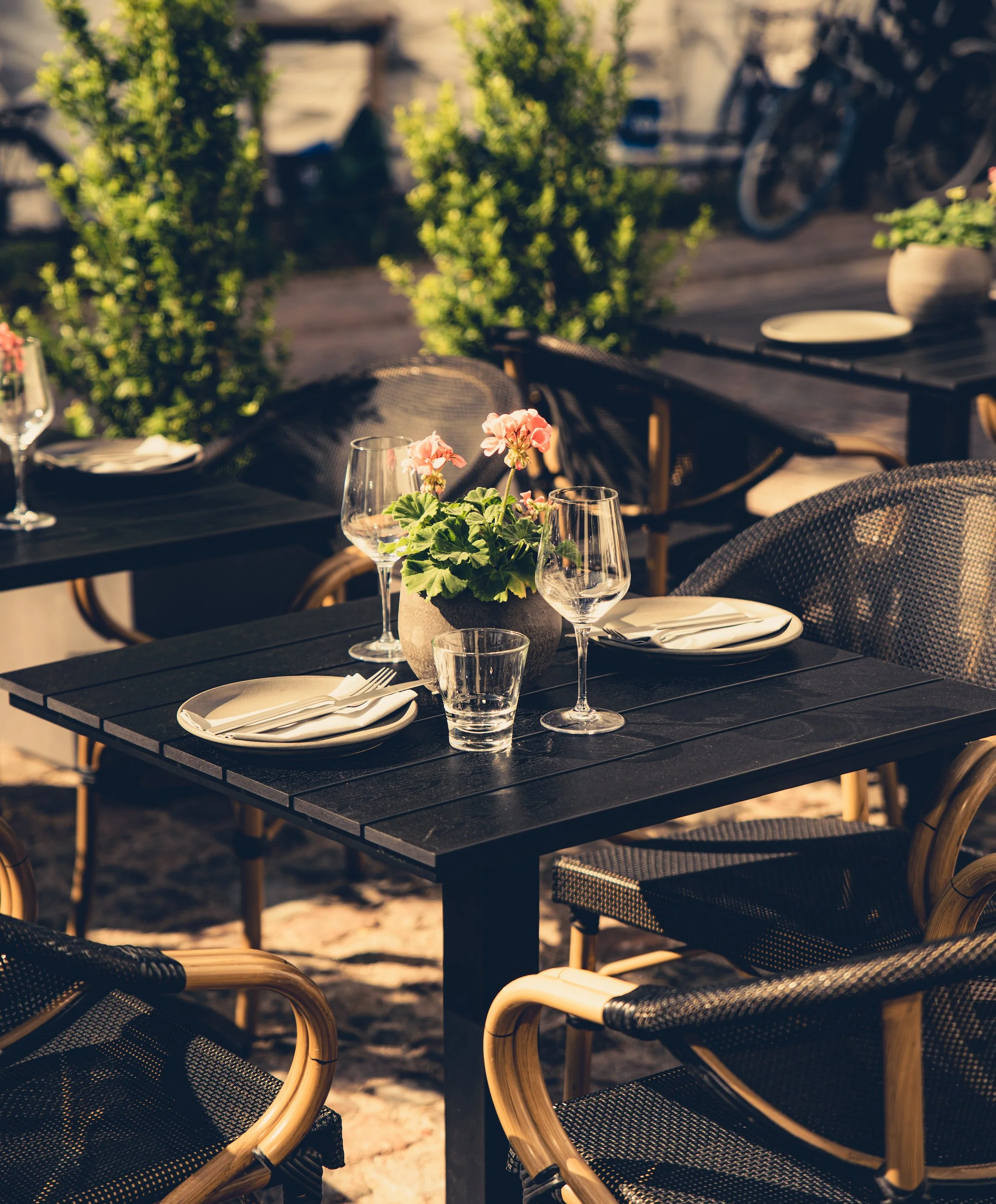 Outdoor terrace table set for dinner at Zahida restaurant in central Copenhagen with wine glasses, plates, and flowers