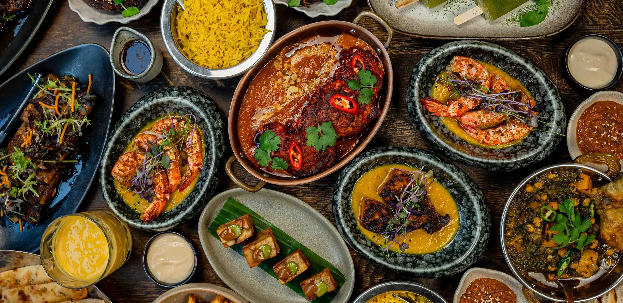 Indian-Pakistani dishes at Zahida in Copenhagen – curry in a copper pan with fresh chilli and coriander, tiger prawns in coconut sauce, pumpkin and chickpea saag, yellow rice and chutneys