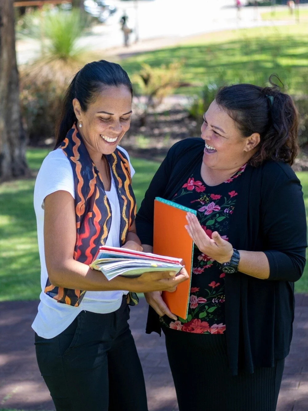 two teachers in a meeting collaborating reading paperwork