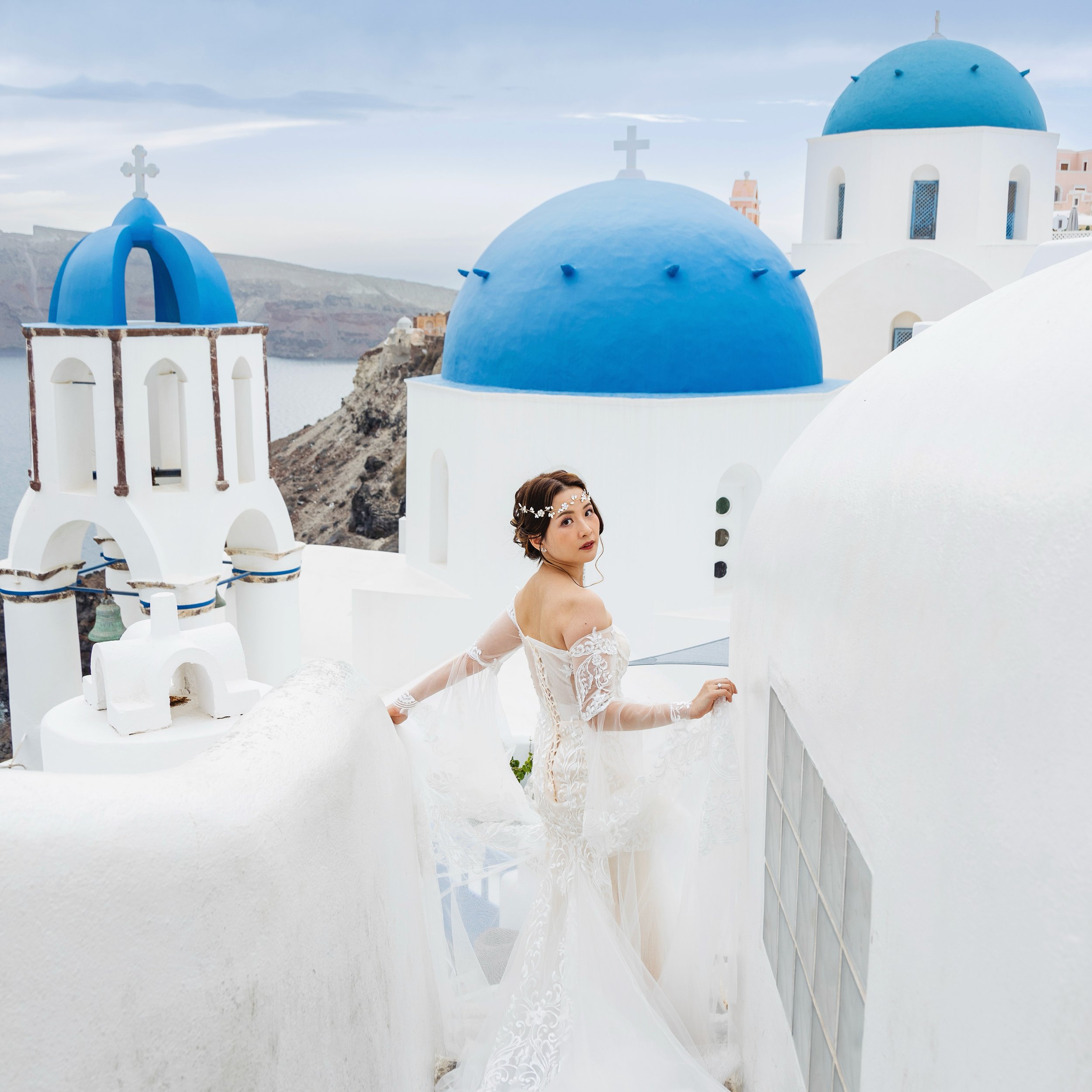 Santorini wedding photography candid couple toast at Santo Wines terrace during sunset, capturing natural emotion, wine props and caldera backdrop.