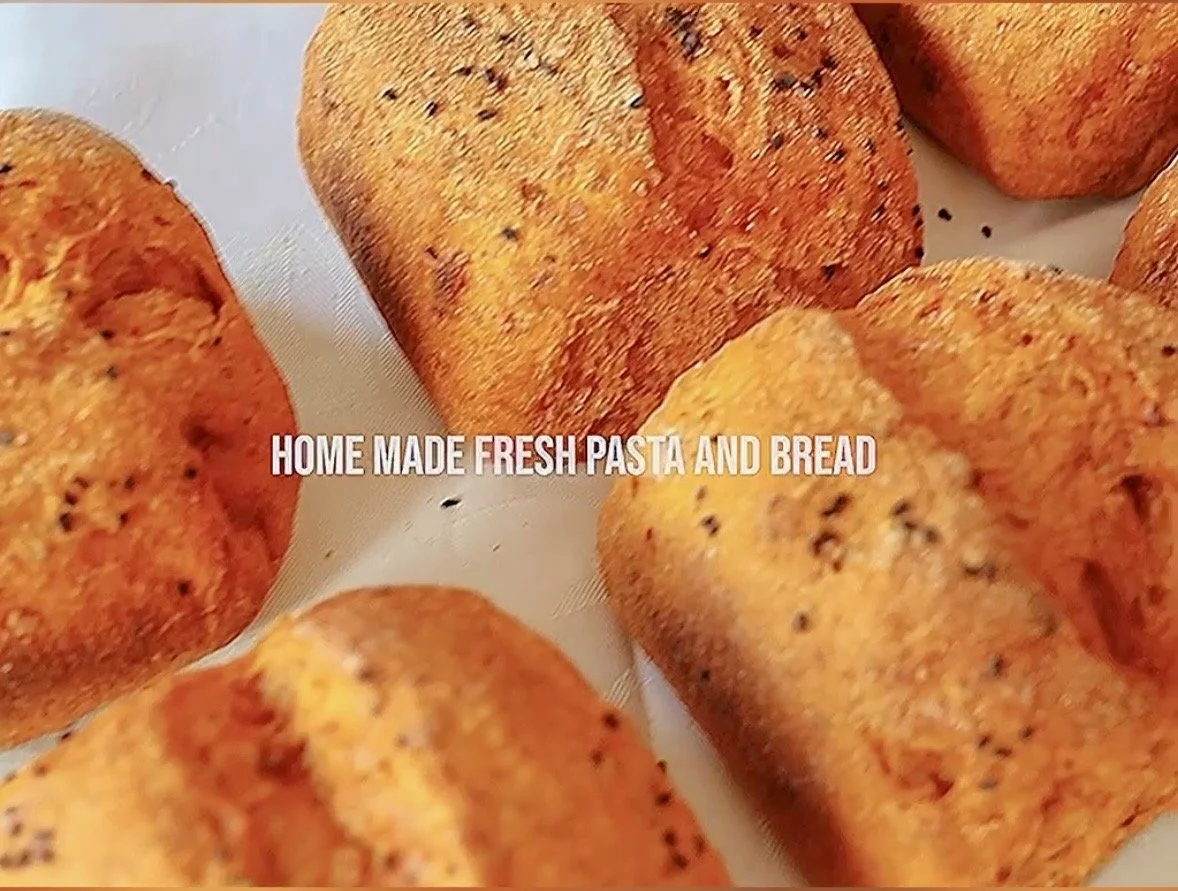 Rustic Santorini sundried tomato sourdough loaf from Karma Greek Restaurant served warm with creamy Santorini fava and lemon, showcasing fresh daily sourdough texture.