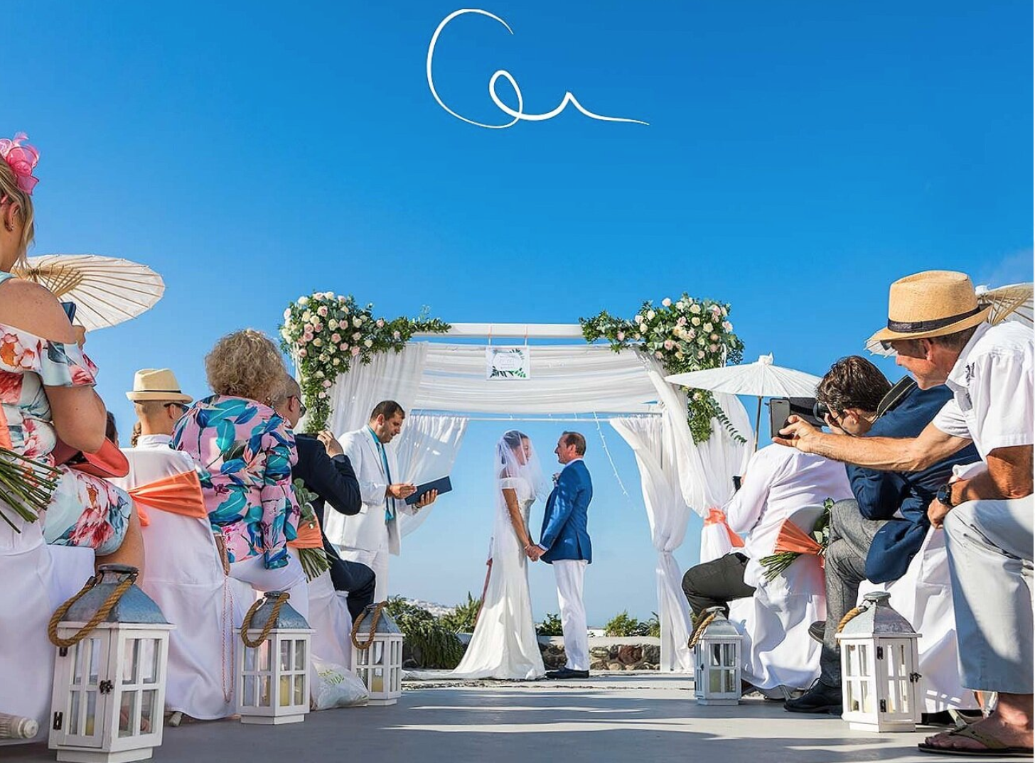 Santorini wedding photography moody editorial shot at Red Beach with volcanic red cliffs, rugged textures and high‑contrast cinematic styling.