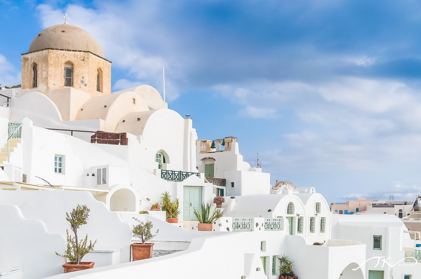 Perissa black sand beach and beachfront cafés with volcanic backdrop — Santorini beach guide and transport tip from Fira. Perissa 黑沙灘與海濱咖啡館，火山景色為背景 — Santorini 海灘指南與 Fira 交通建議。