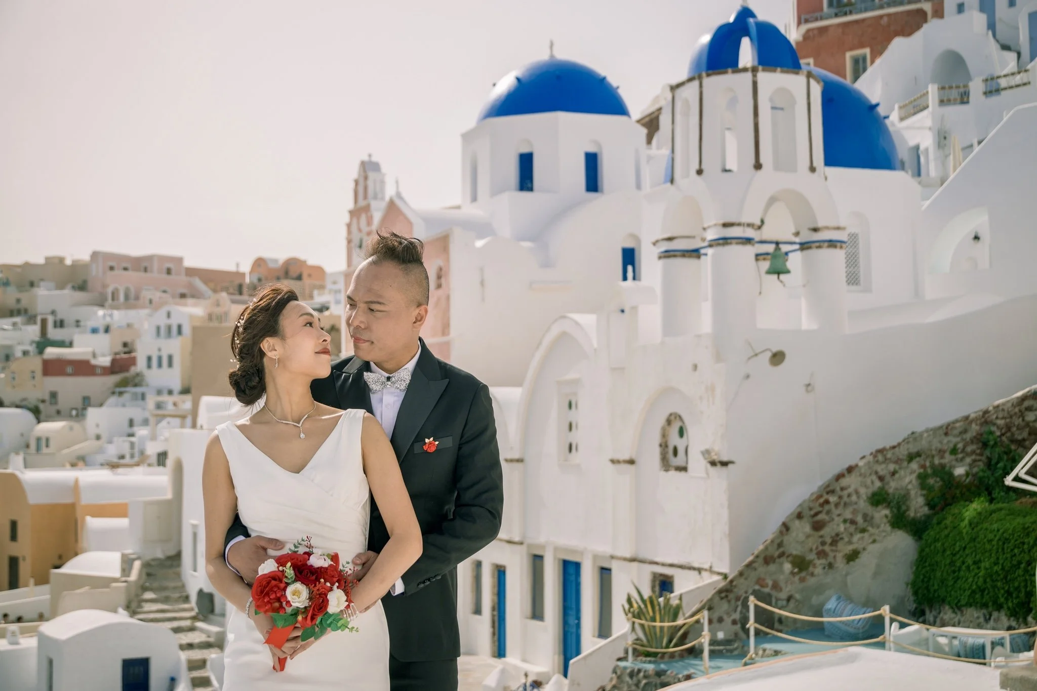 Santorini wedding photography engagement lifestyle on Santo Wines terrace at sunset with panoramic caldera views, wine barrels and candid couple moments.