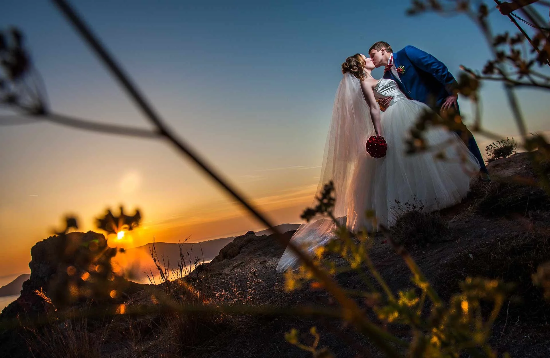 Santorini wedding photography couple on Imerovigli with Skaros Rock backdrop, dramatic cliffside composition and soft golden light for intimate portraits.