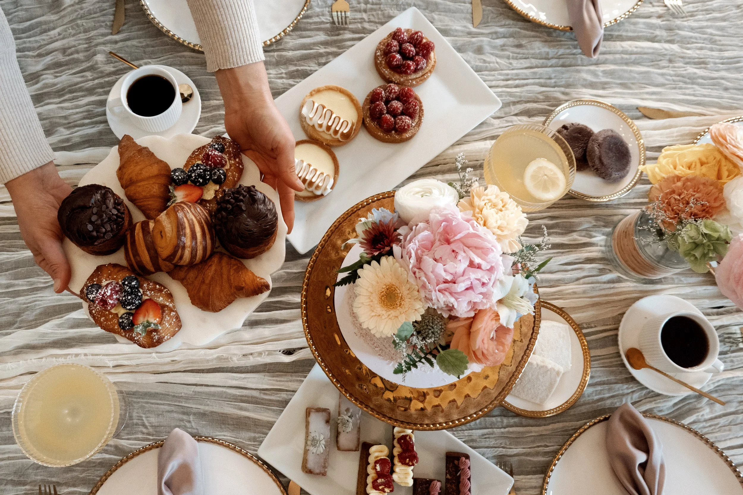 Collection of Mother's Day pastries, flowers, and desserts on table - perfect for gifting.