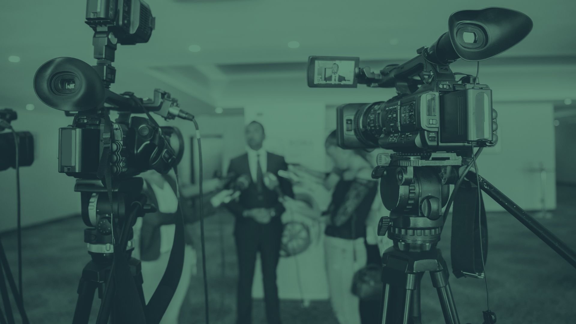 A man is prepared by his PR team for a TV interview.