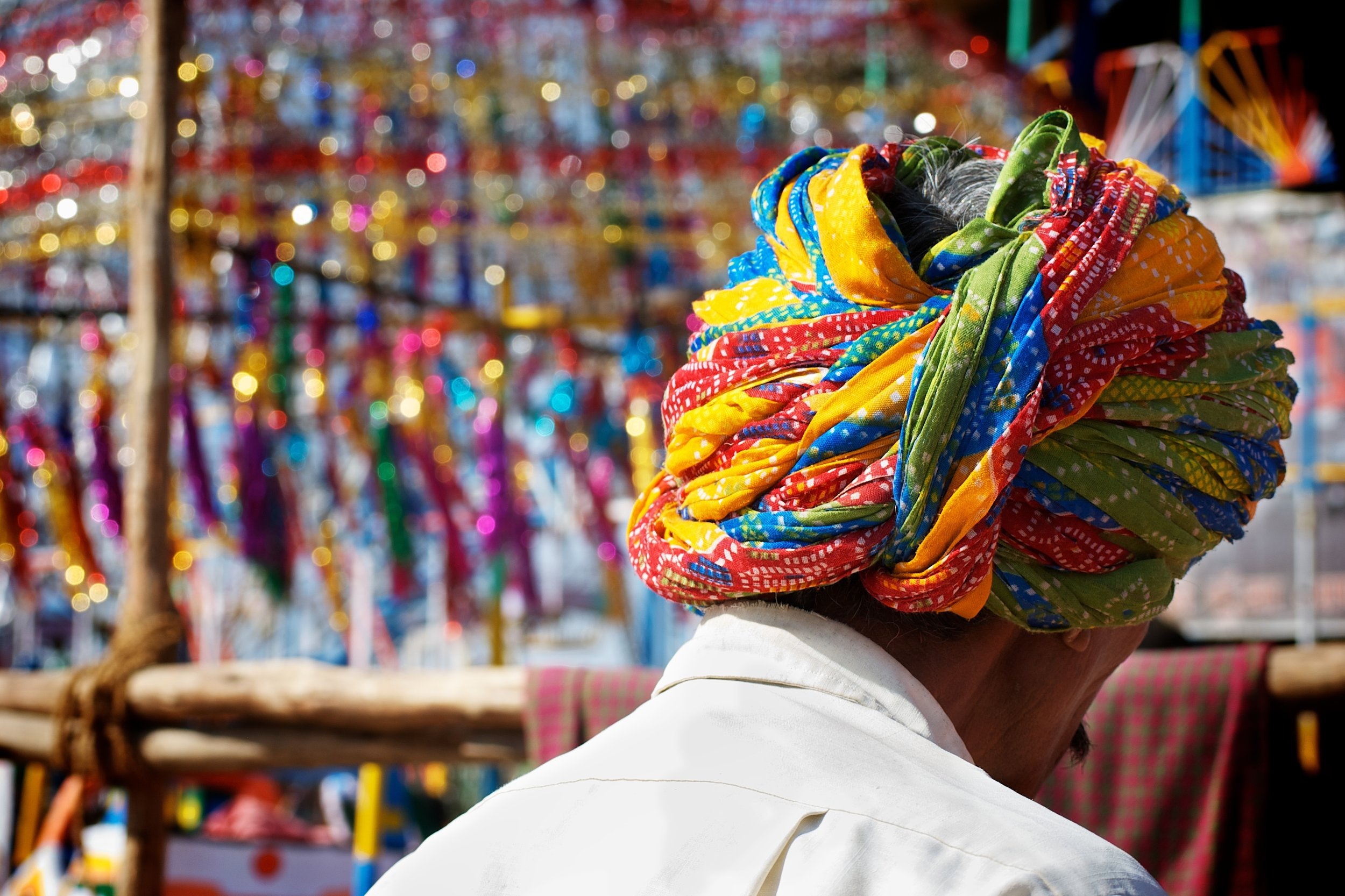 Man wearing a turban in a market place in India.jpg
