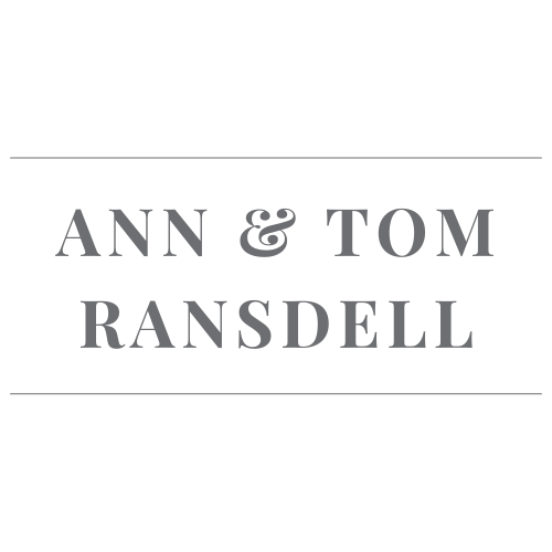 A black and gray logo with the names 'Ann & Tom Ransdell' in the center.