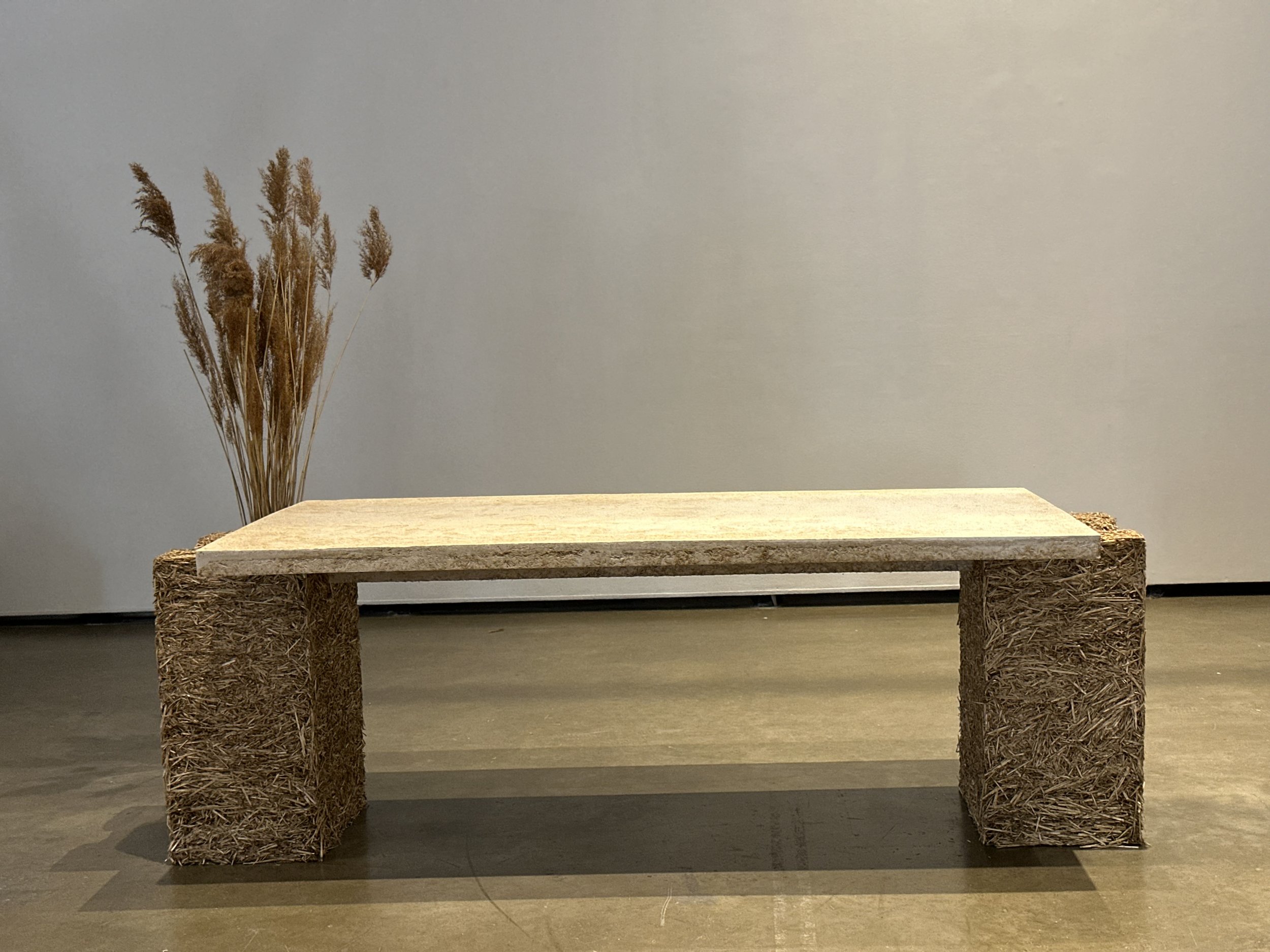 Banc en bois avec pieds en fibres naturelles dans une pièce sombre.