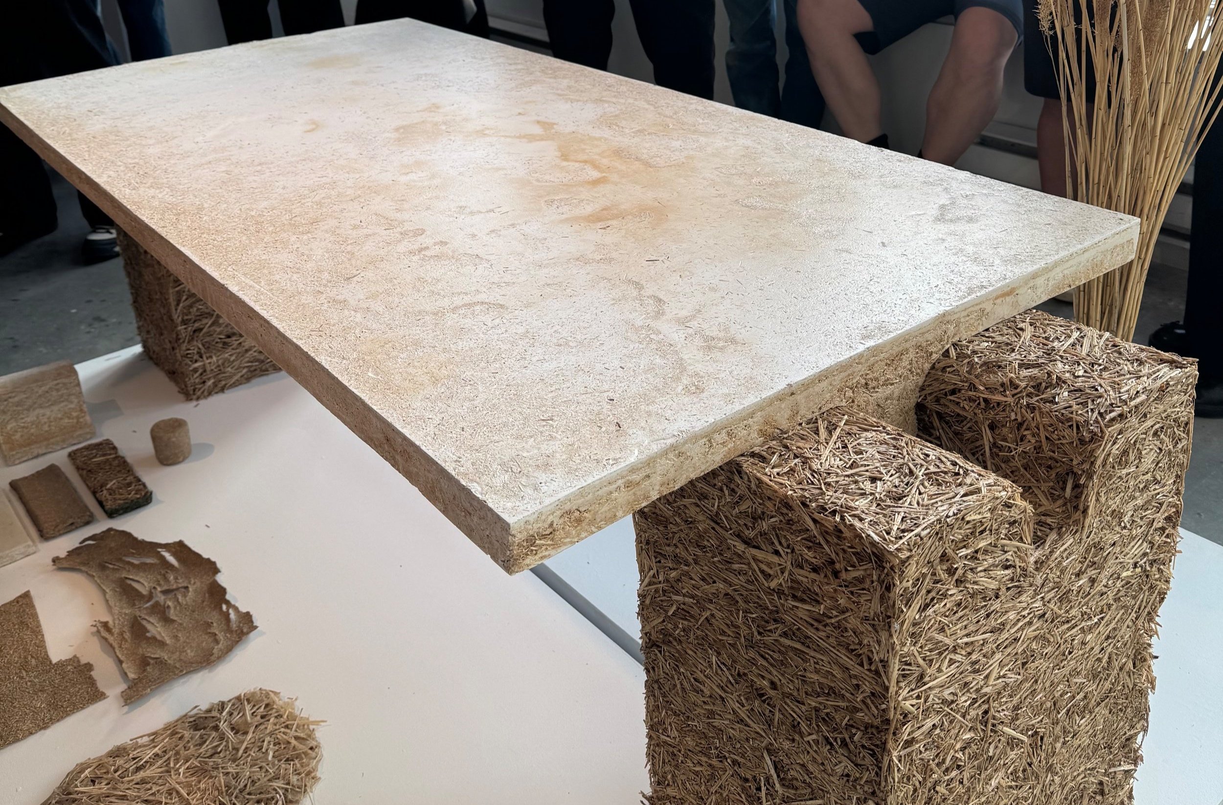 Une table avec un plateau en pierre reposant sur un support en paille compressée.