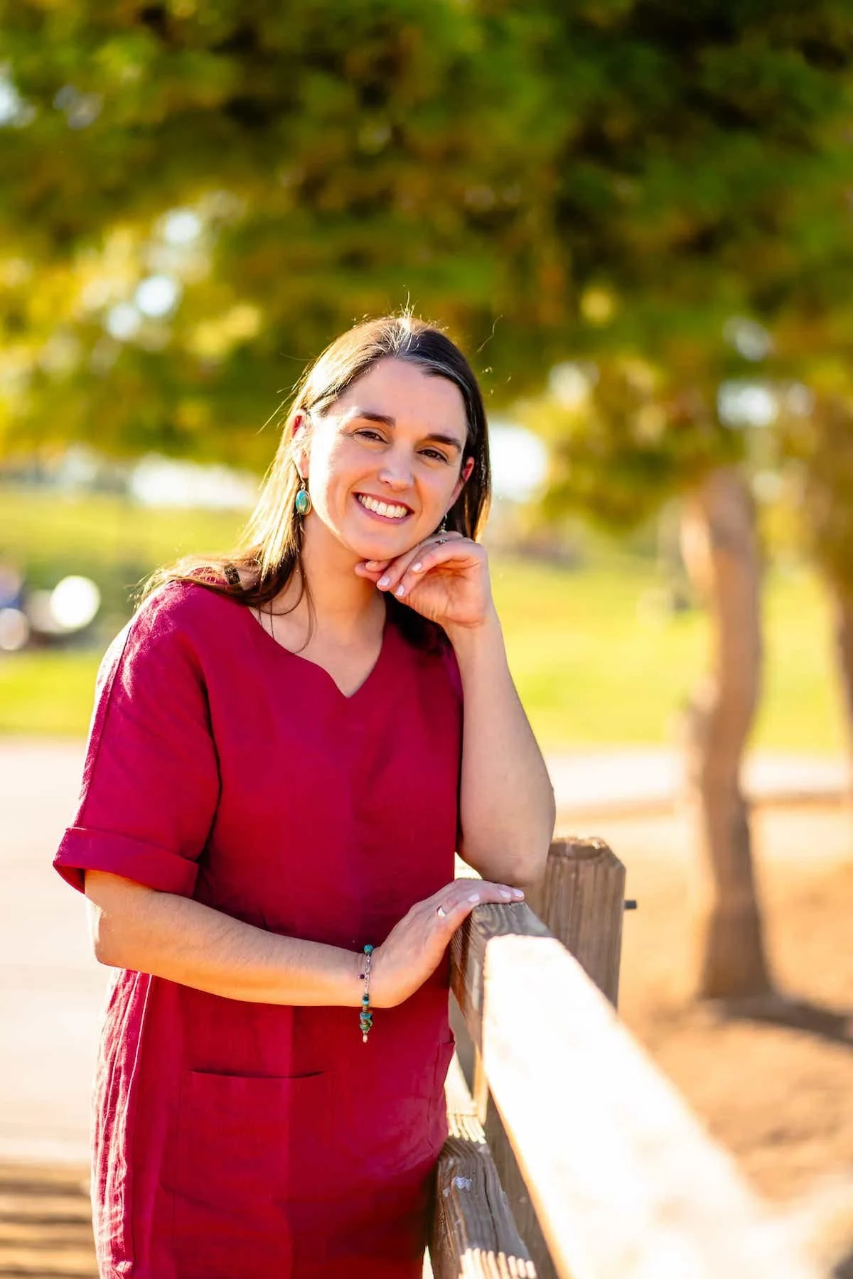 Therapist Tara Nicotra Clemente standing outside with face on hand and elbow on fence