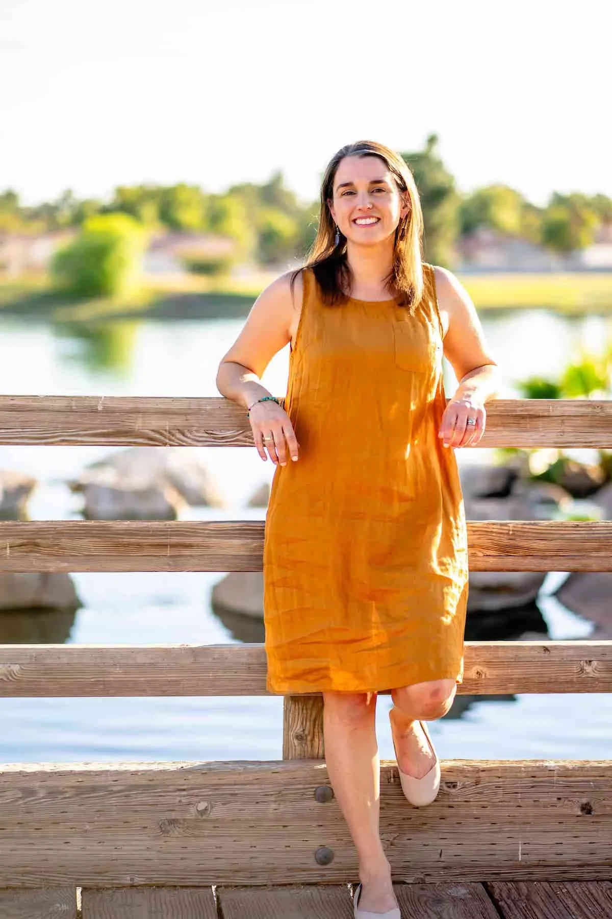 Therapist Tara Nicotra Clemente standing outside against fence with river and rocks behind her