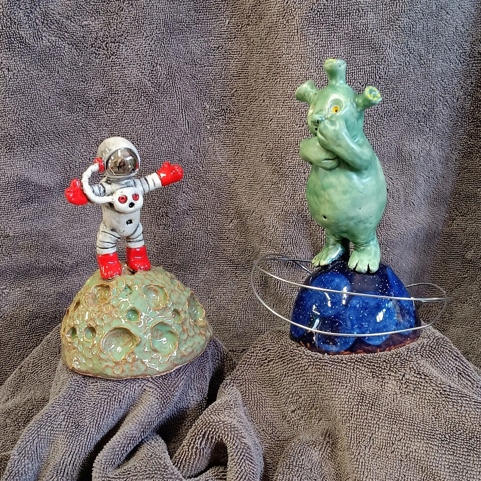 Alien and spaceman, white earthenware clay, fired to cone 05, anodized aluminum wire