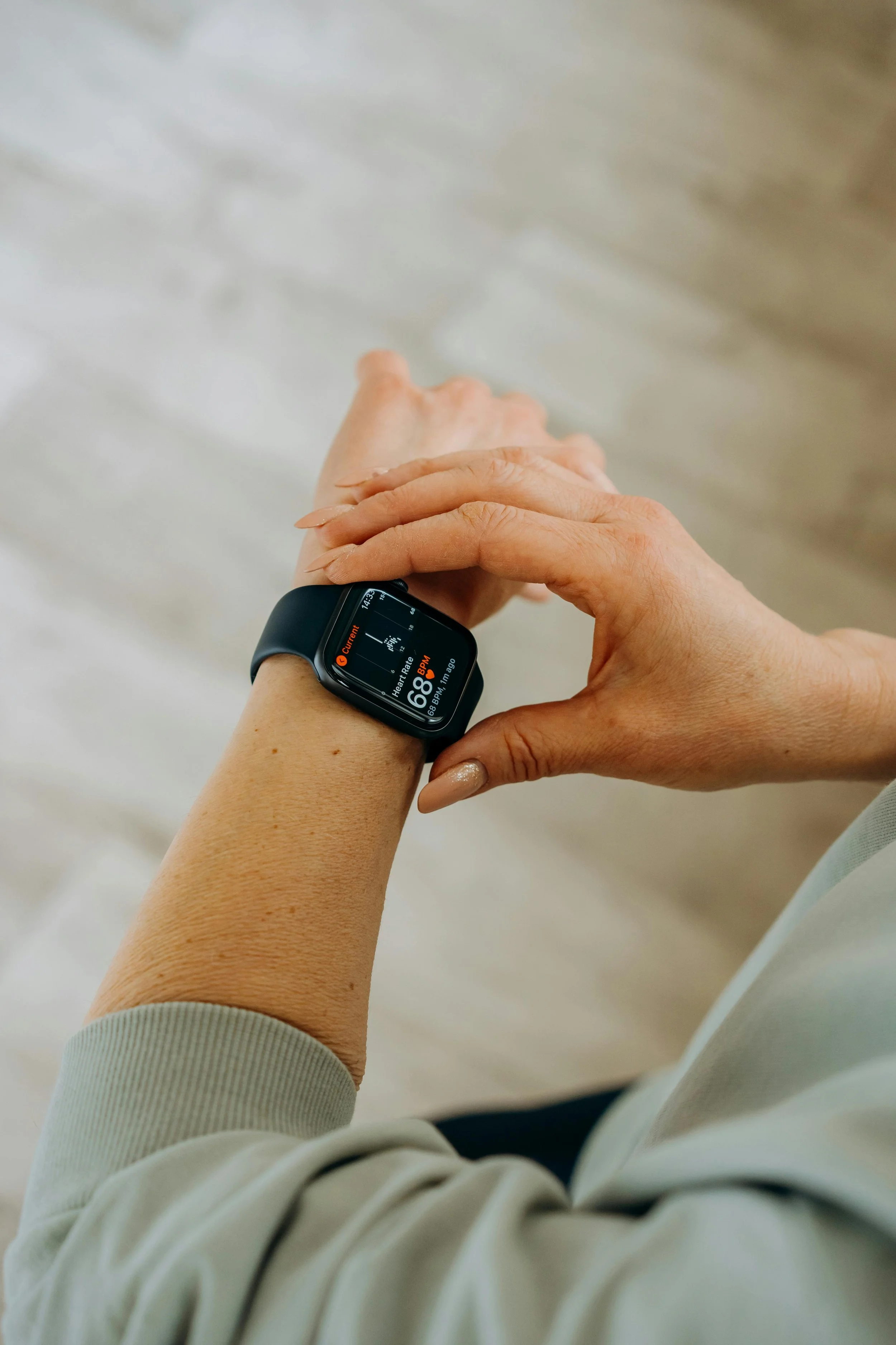 Person checking a fitness tracker on their wrist, representing the emotional toll of constant health tracking