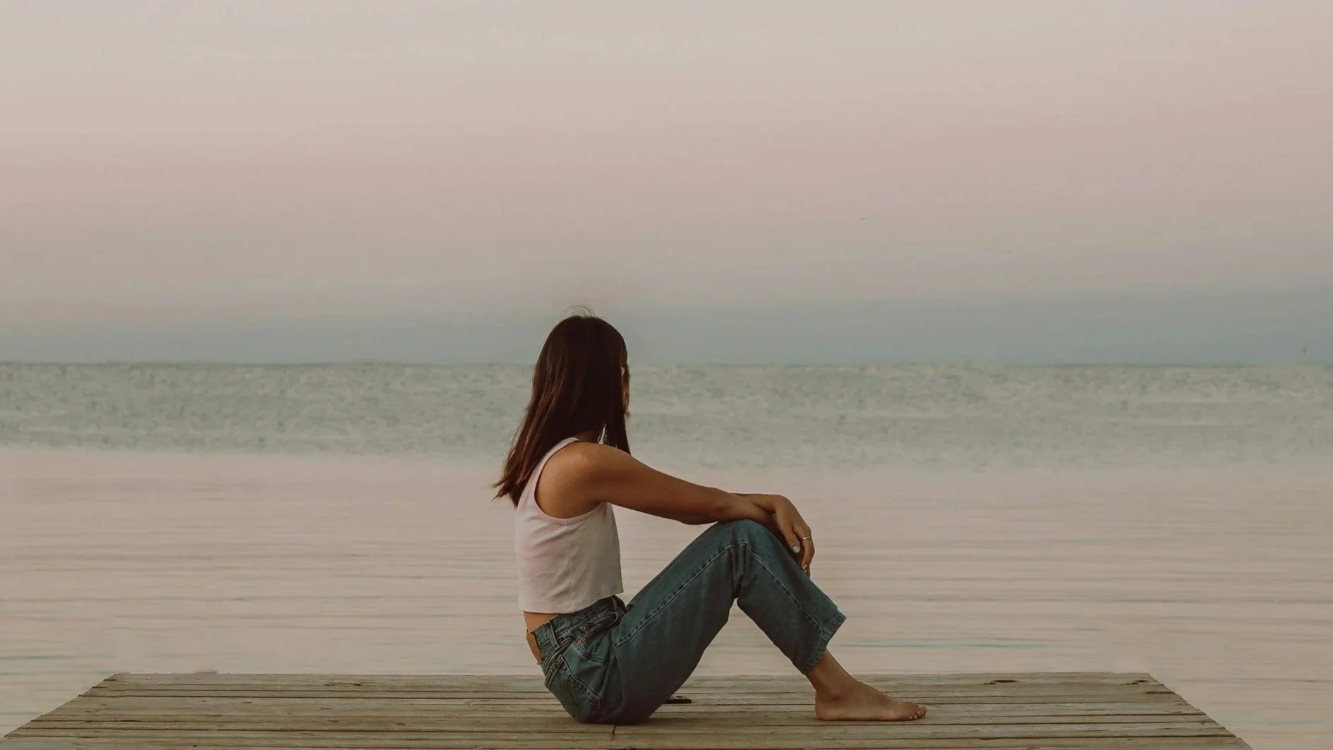 a person sitting looking hopefully out at the LA ocean, burnout therapy, representing the recovery work tech professionals do to address chronic stress and nervous system dysregulation