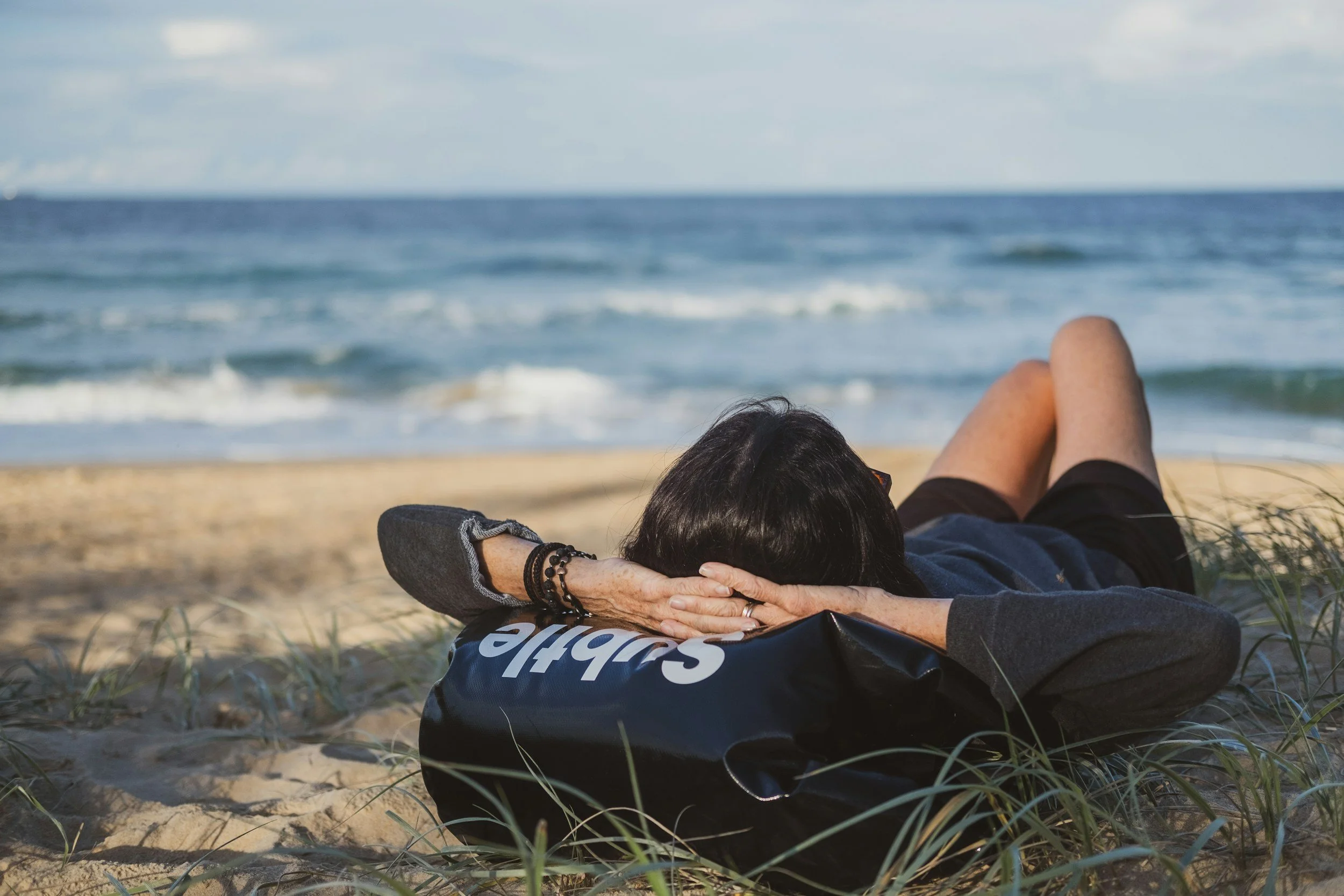 Person resting on a beach in san francisco representing the challenge of rest and recovery for high achievers experiencing burnout