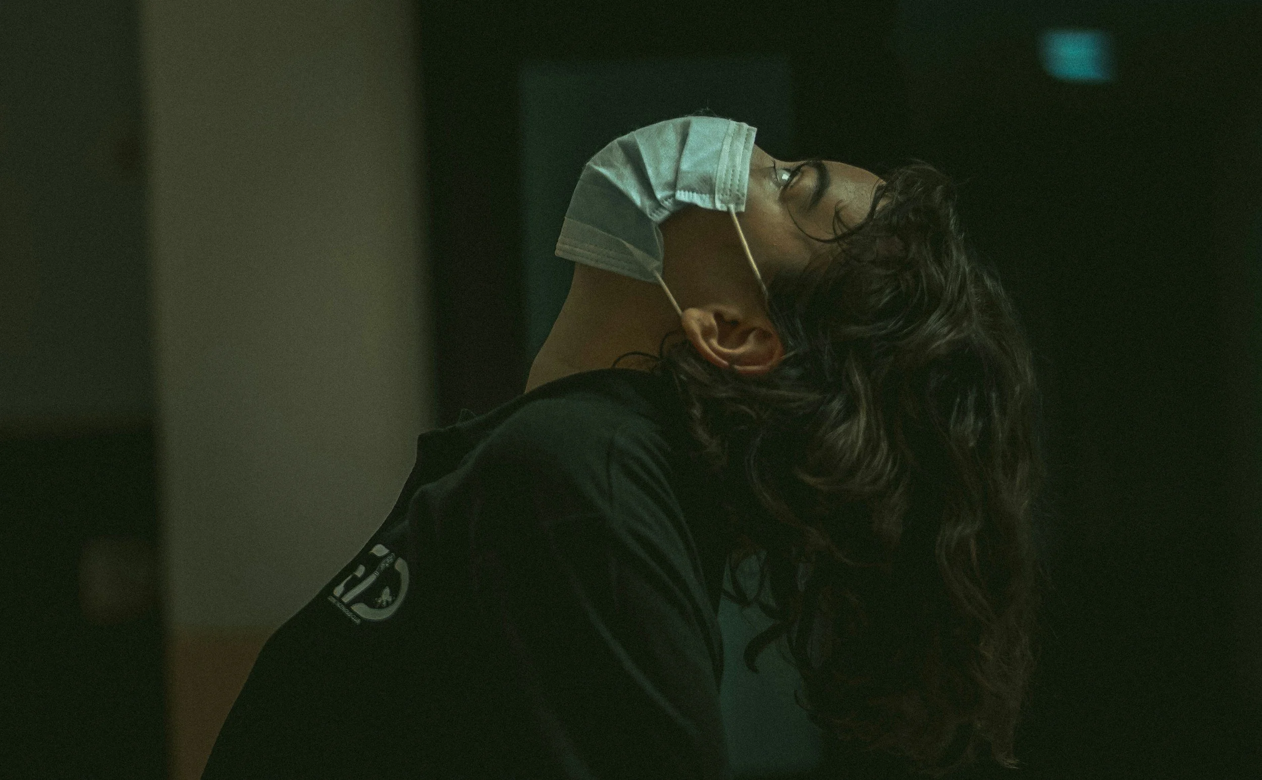 an exhausted healthcare worker tipping their head back in overwhelm