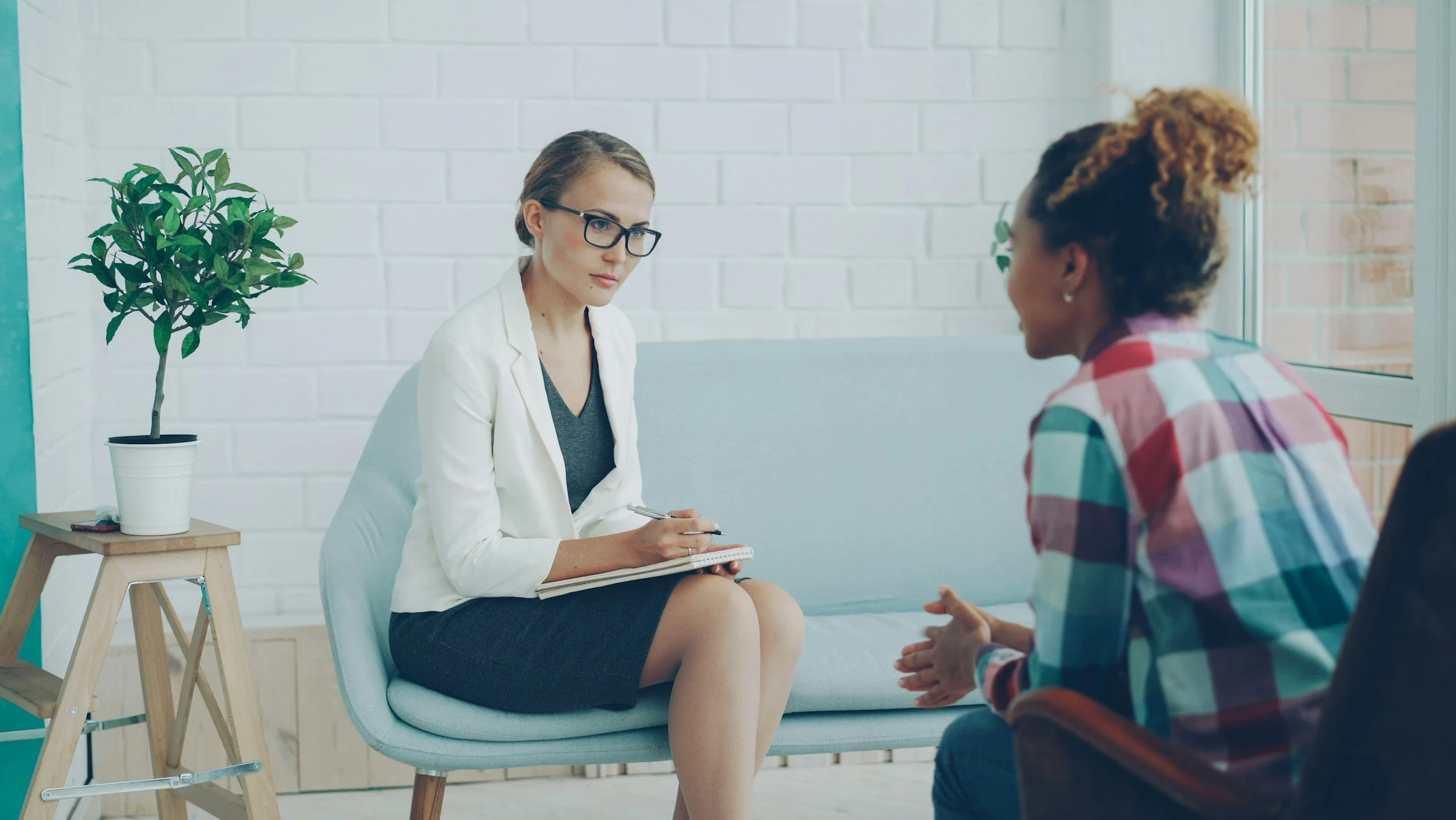 Therapist taking notes during a therapy session to show how teletherapy works