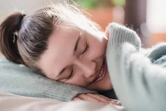 a woman smiling as she rests her eyes representing the tiredness and satsifaction experienced after a productive emdr therapy session with a san francisco emdr therapist