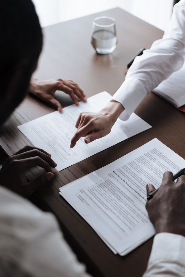 Professionals sitting at a desk looking over documents representing the performance review process in a high-pressure workplace