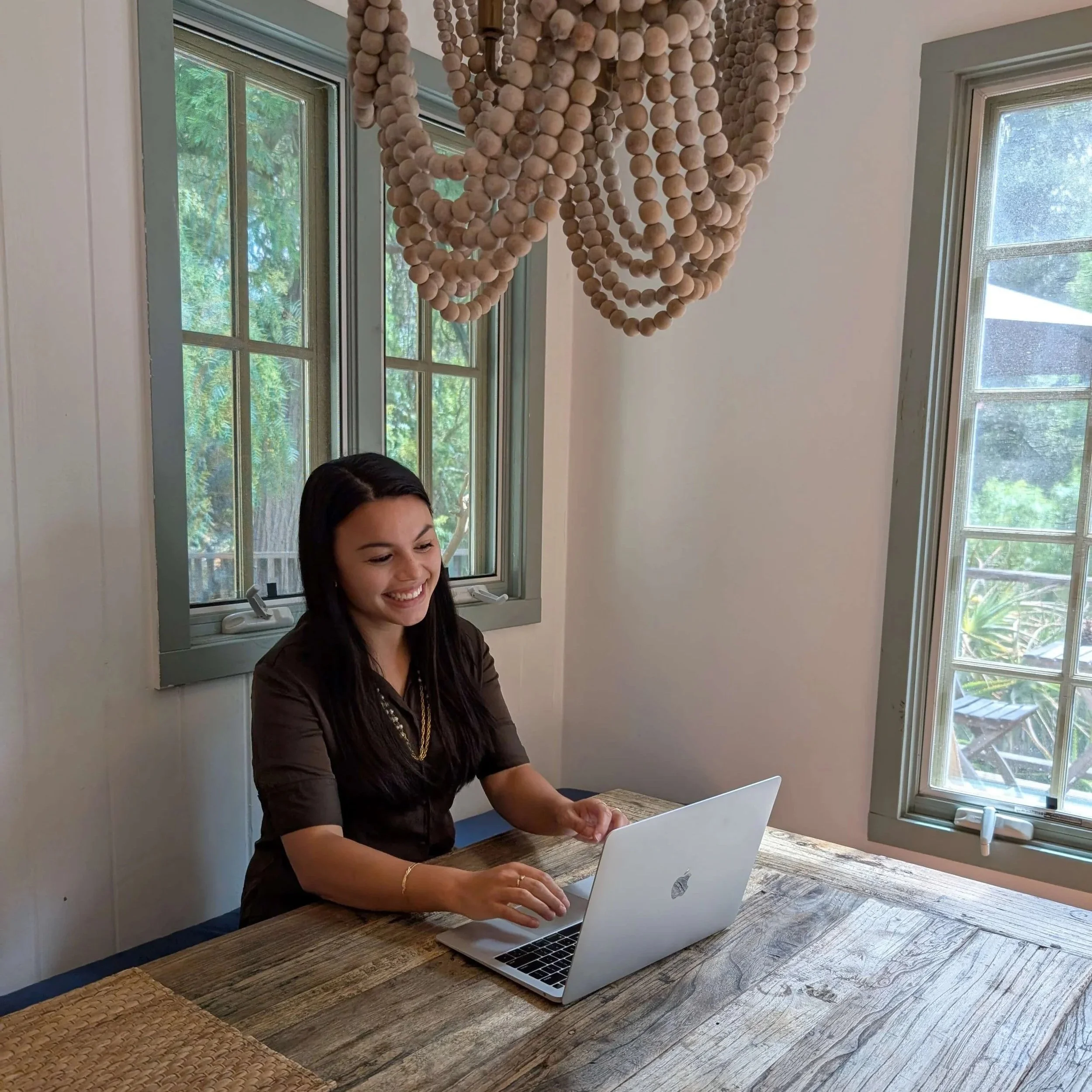 california emdr therapist daniella mohazab smiling at her laptop representing the start of a great holistic therapy session or emdr therapy session in california