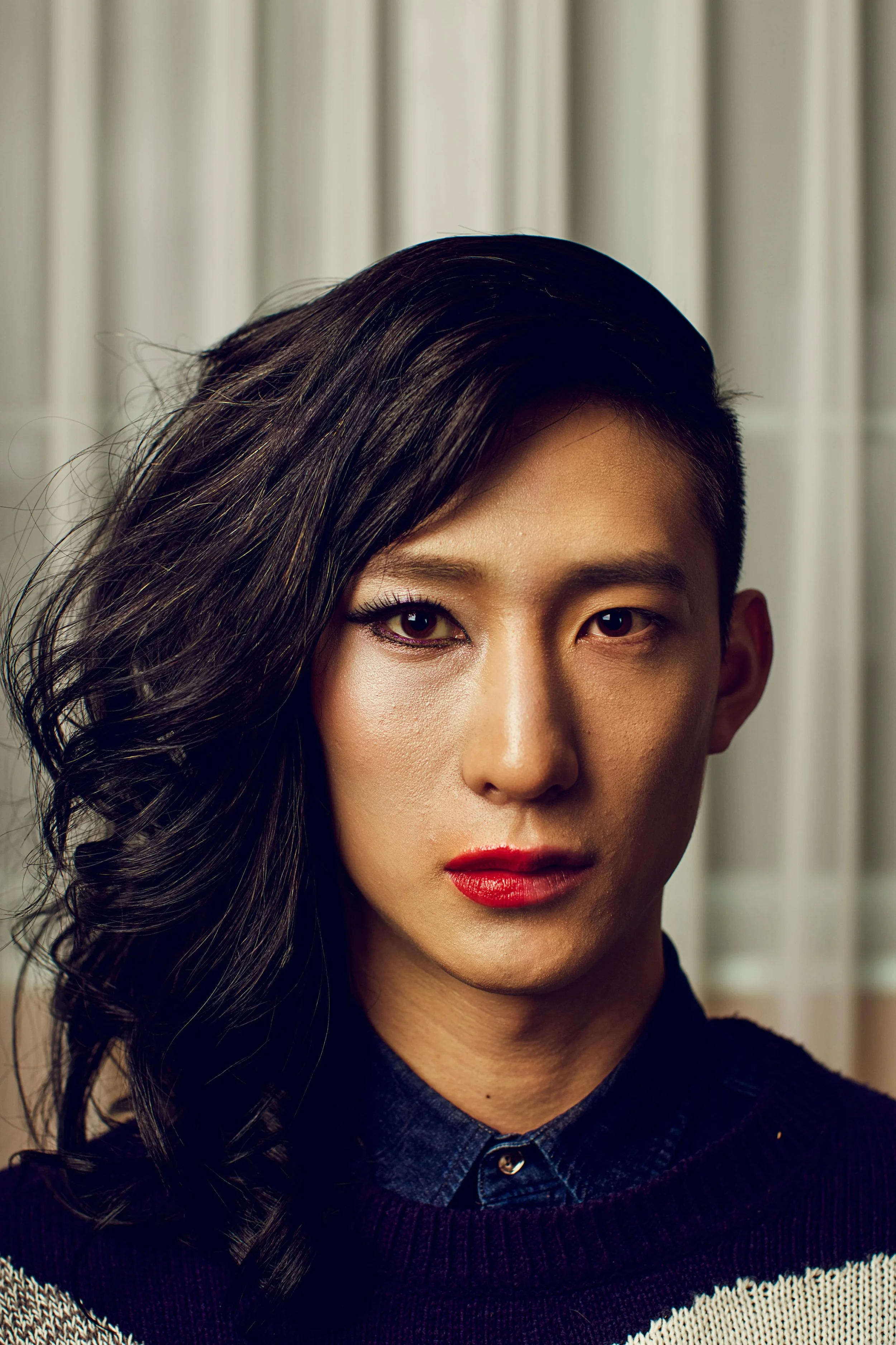 a person with half their face and hair done in a feminine style and half done in a masculine style representing trans identity and growth through LGBT affirming therapy in florida and california