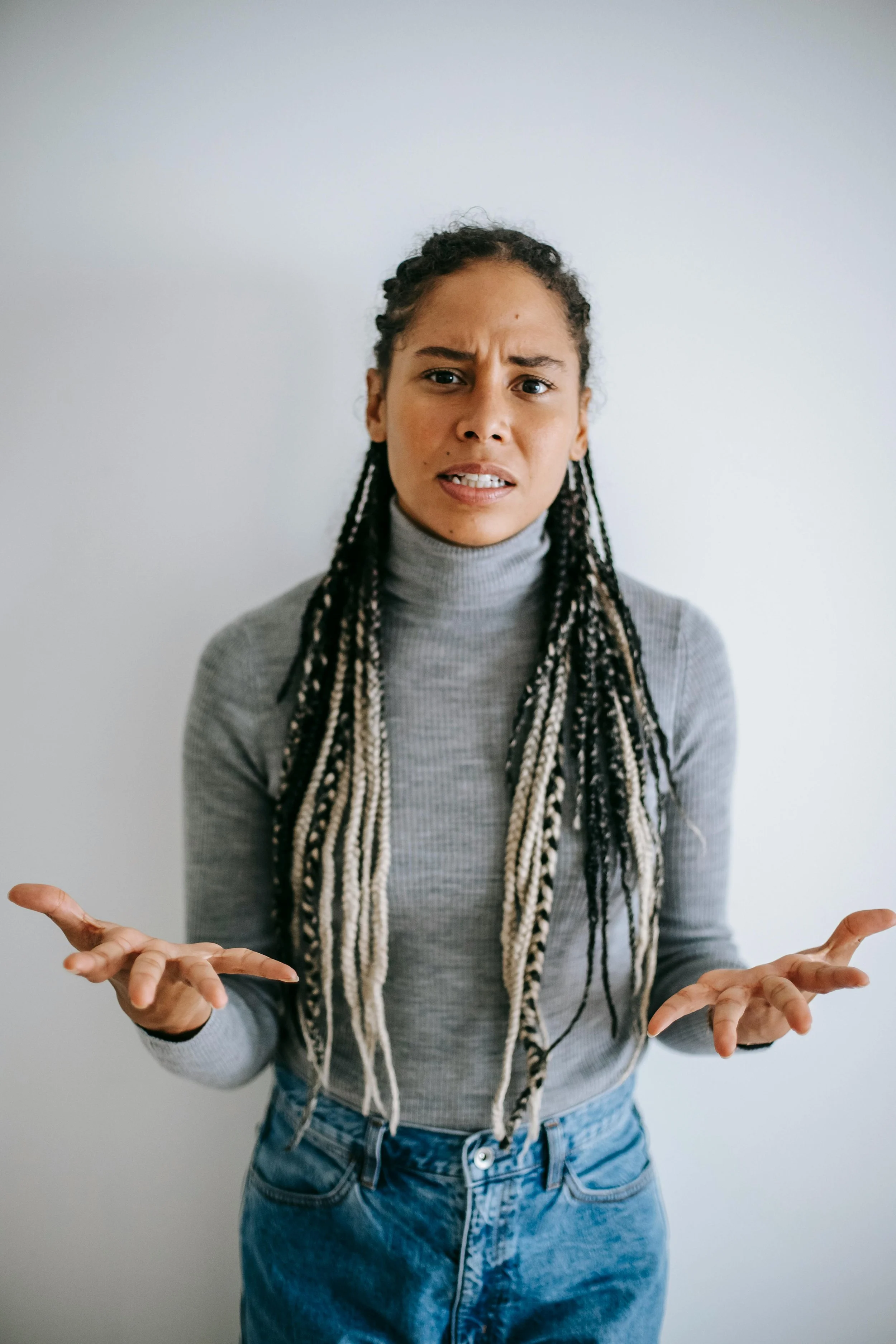 a woman with long braids holding her hands out in frustration representing someone who is frustrated by ineffective anxiety therapy and how working with a great anxiety therapist can help.