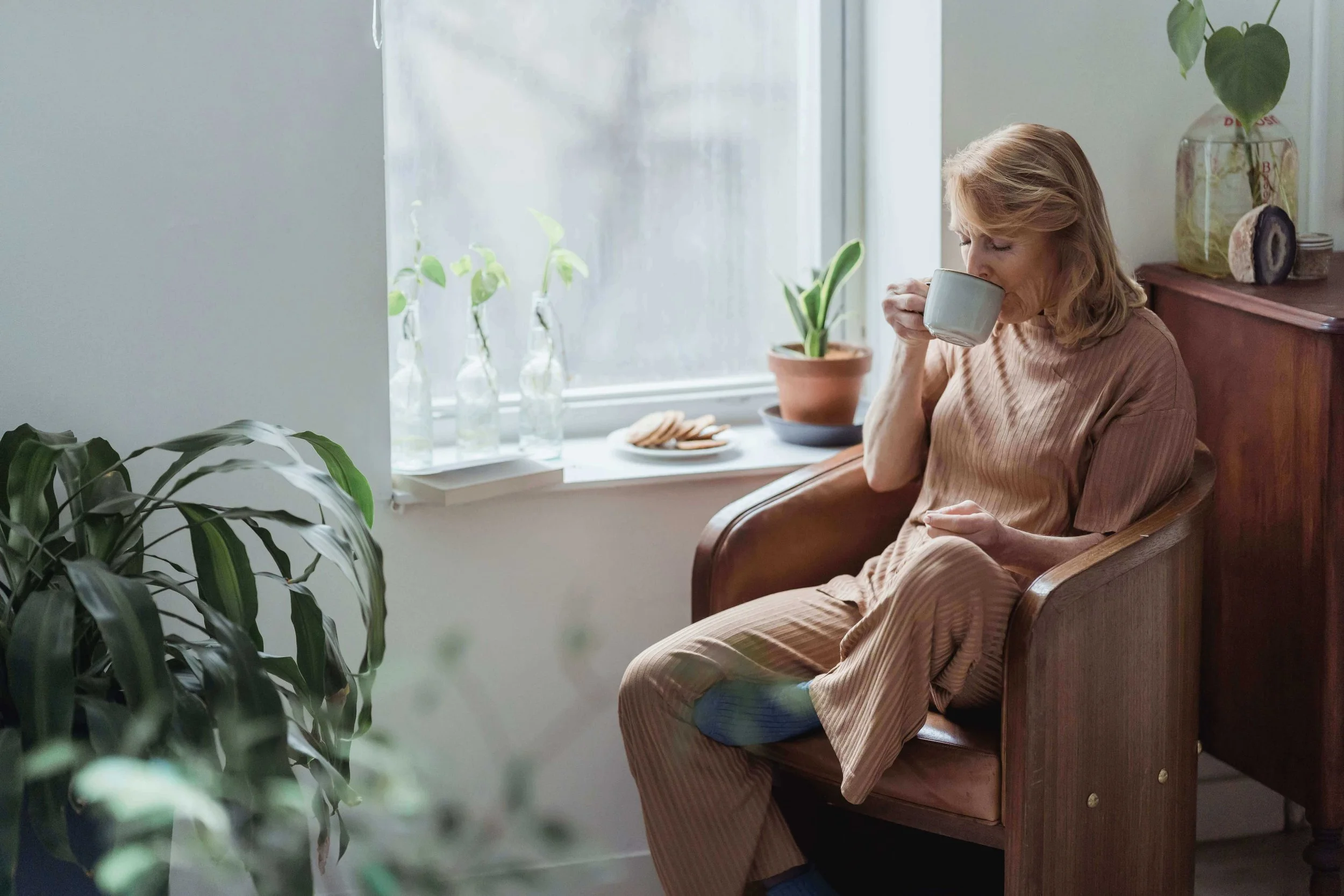 Person peacefully sipping tea representing calm and nervous system recovery after trauma therapy