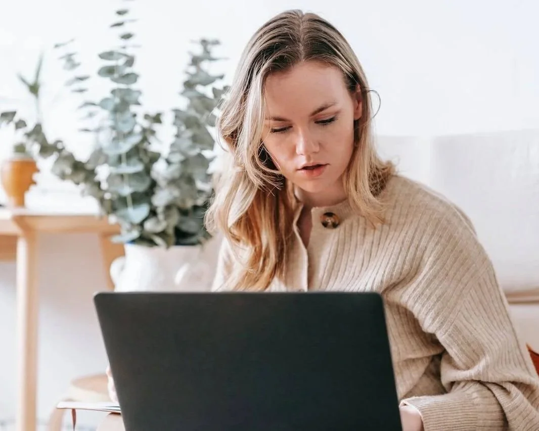 Woman on a laptop participating in an online EMDR therapy session from home