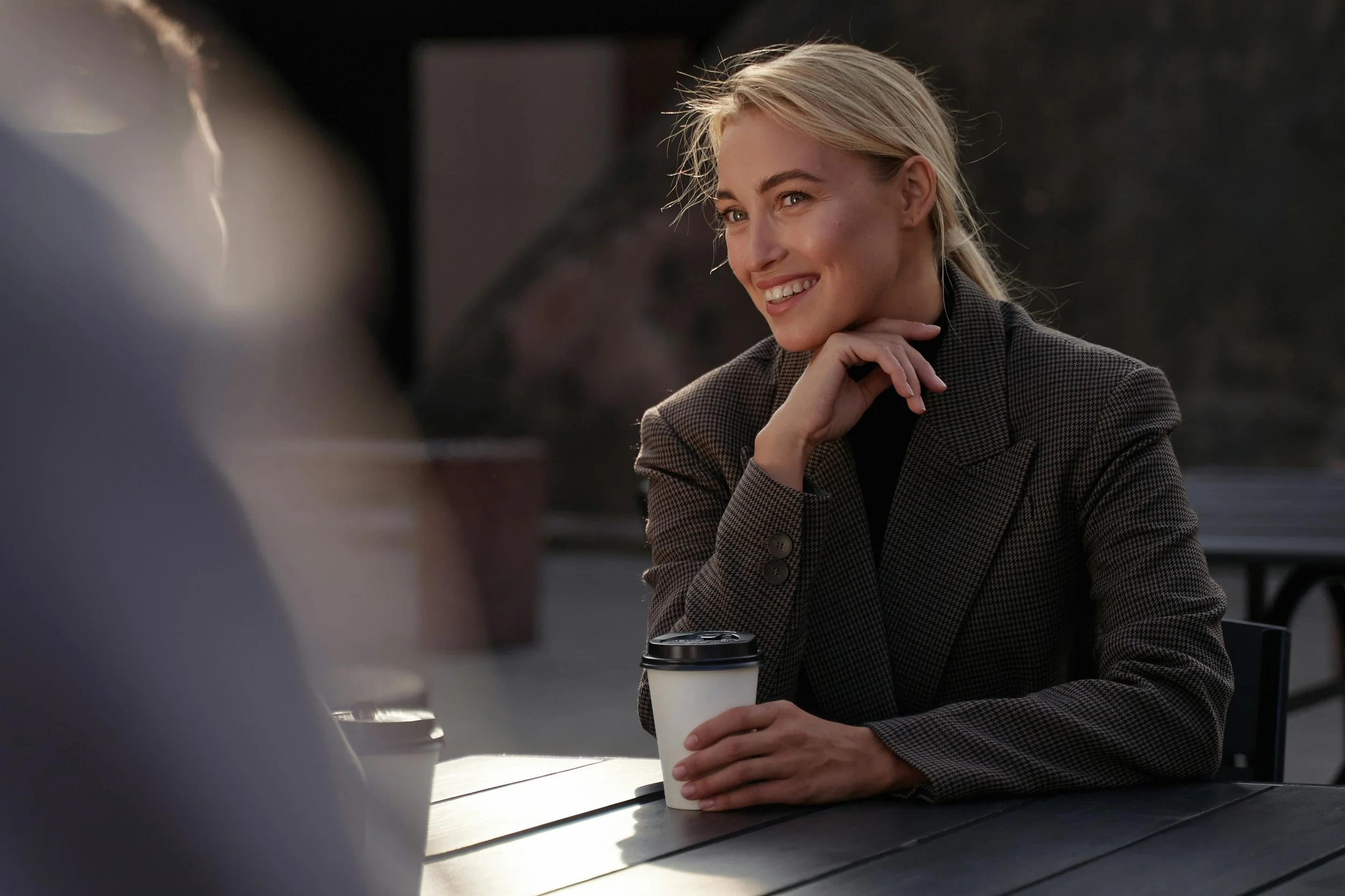 a woman smiling over coffee, representing the window of tolerance, the zone where EMDR processing can happen without overwhelming the nervous system