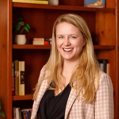 Laurel van der Toorn, LMFT, smiling in front of a bookshelf