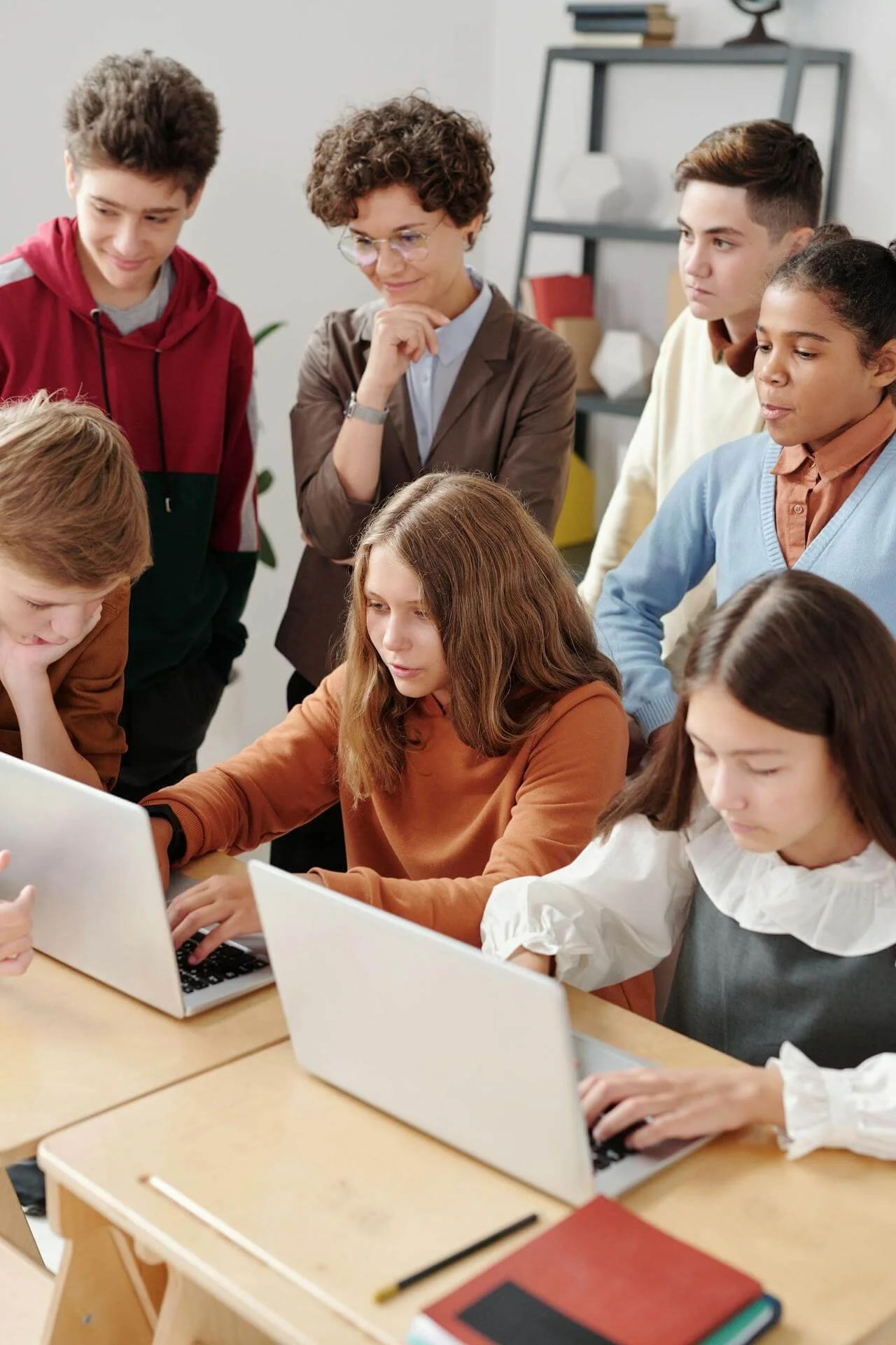a group of teenagers in front of two laptops representing how common AI use is among teenagers today and how to help your teen develop a healthy ethical stance on using AI in school through therapy for teenagers in california or florida