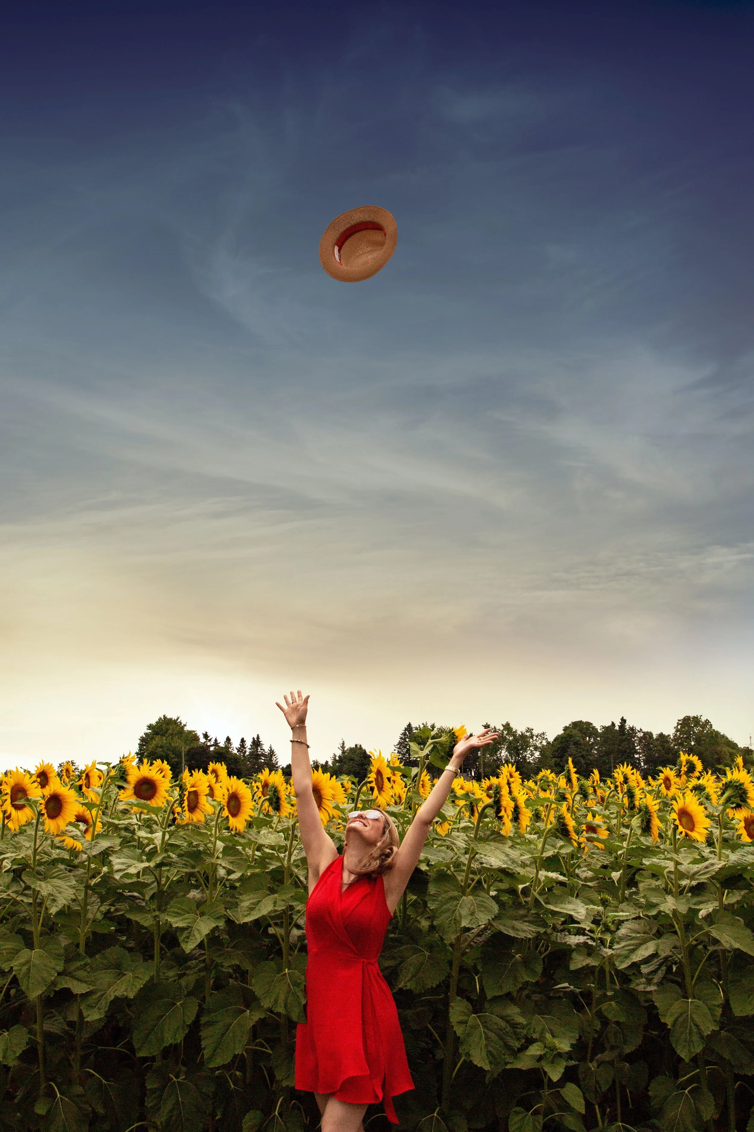 person throwing hat in the air in a field of sunflowers representing the beginning online EMDR intensive therapy for trauma recovery in California or Florida
