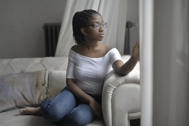 Person sitting quietly in reflection representing the grief of ontological loss and holistic therapy support in California