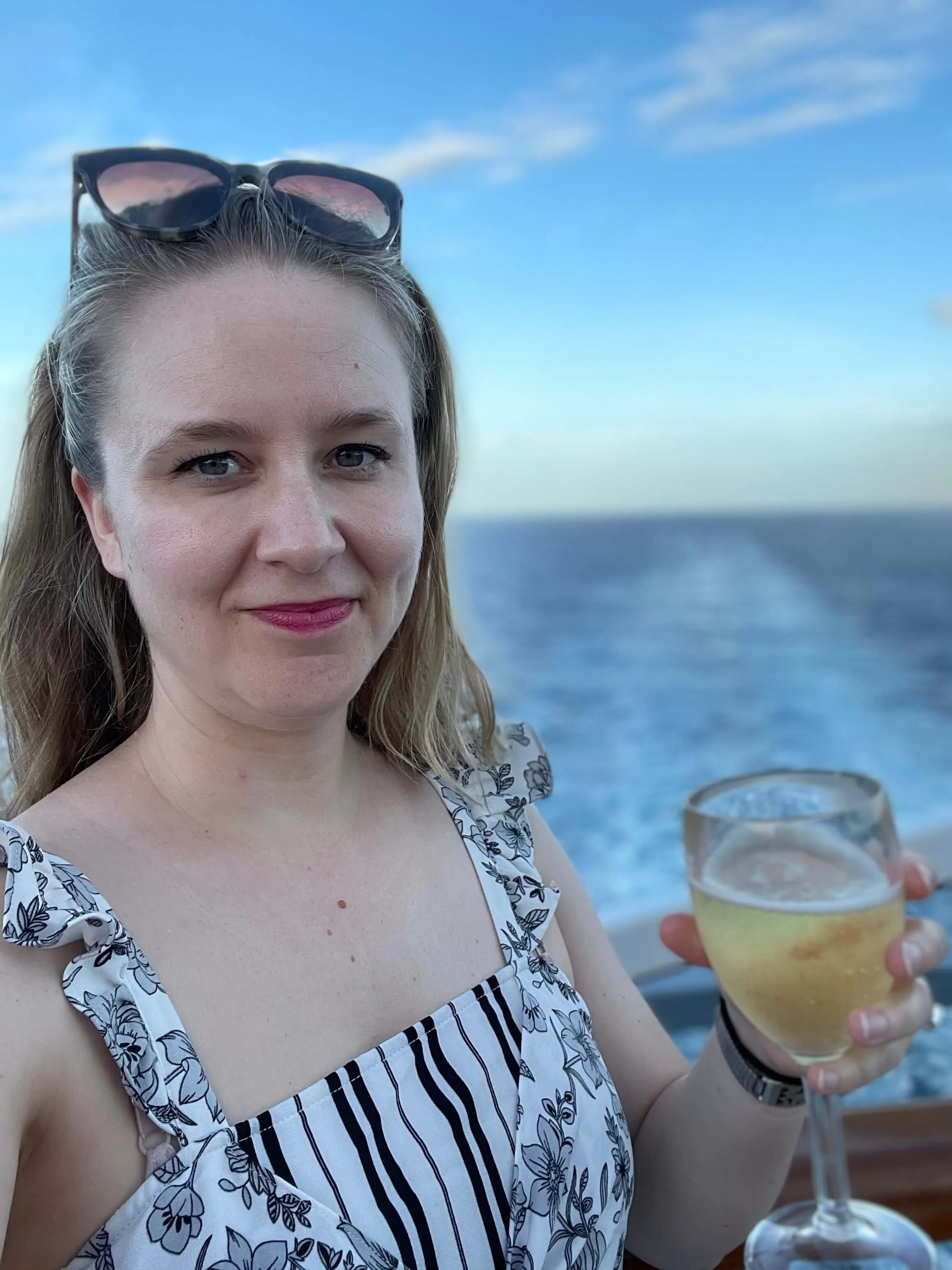 Laurel van der Toorn, LMFT, on a cruise ship with a glass of champagne, representing the practice of fully unplugging from work