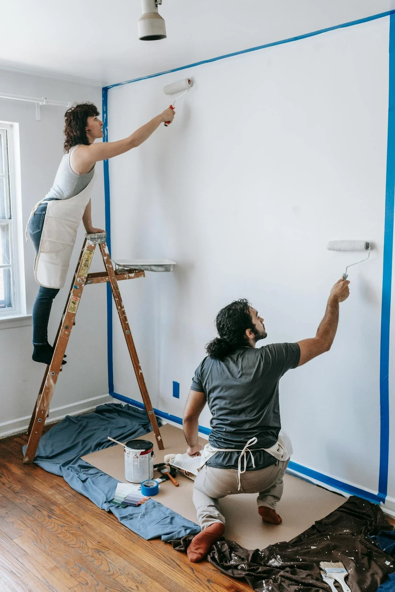 a couple painting a wall together representing shared projects that offer shared meaning and goals, a cornerstone of gottman method couples therapy. we offer couples therapy in los angeles.
