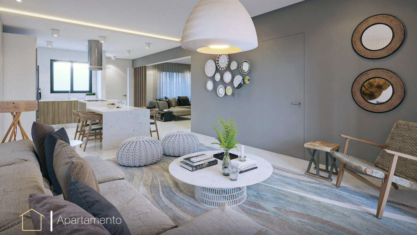 Sala moderna con sofá, mesa de centro blanca, cojines, decoración de pared con platos, lámpara colgante y cocina al fondo.