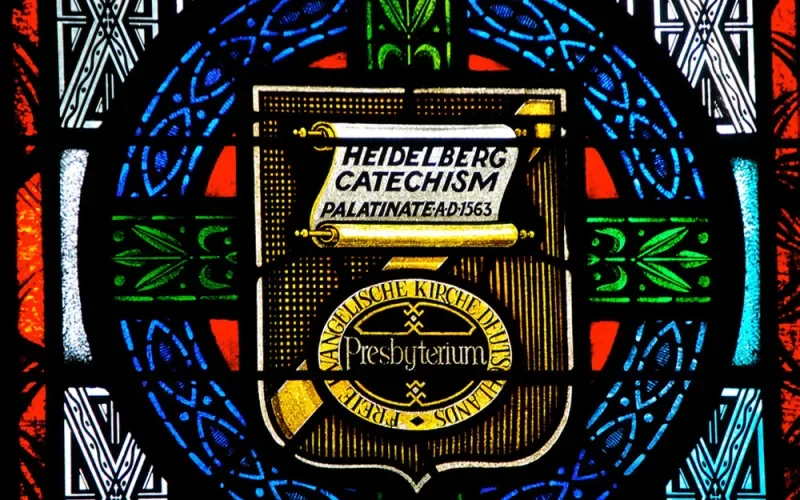 Stained glass window featuring scroll with the words Heidelberg Catechism Palatinate AD 1563